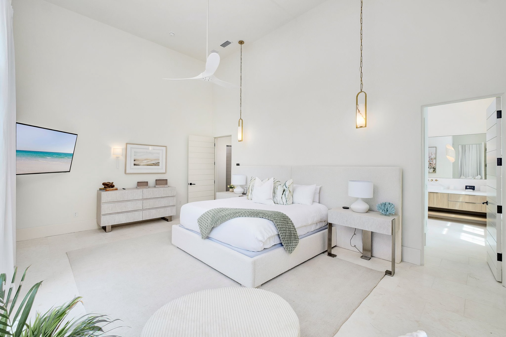 Step into your serene coastal retreat with soaring vaulted ceilings and dreamy white linens. Sink into the plush king bed and let the elegant pendant lights and soft ceiling fan create your perfect haven for relaxation.
