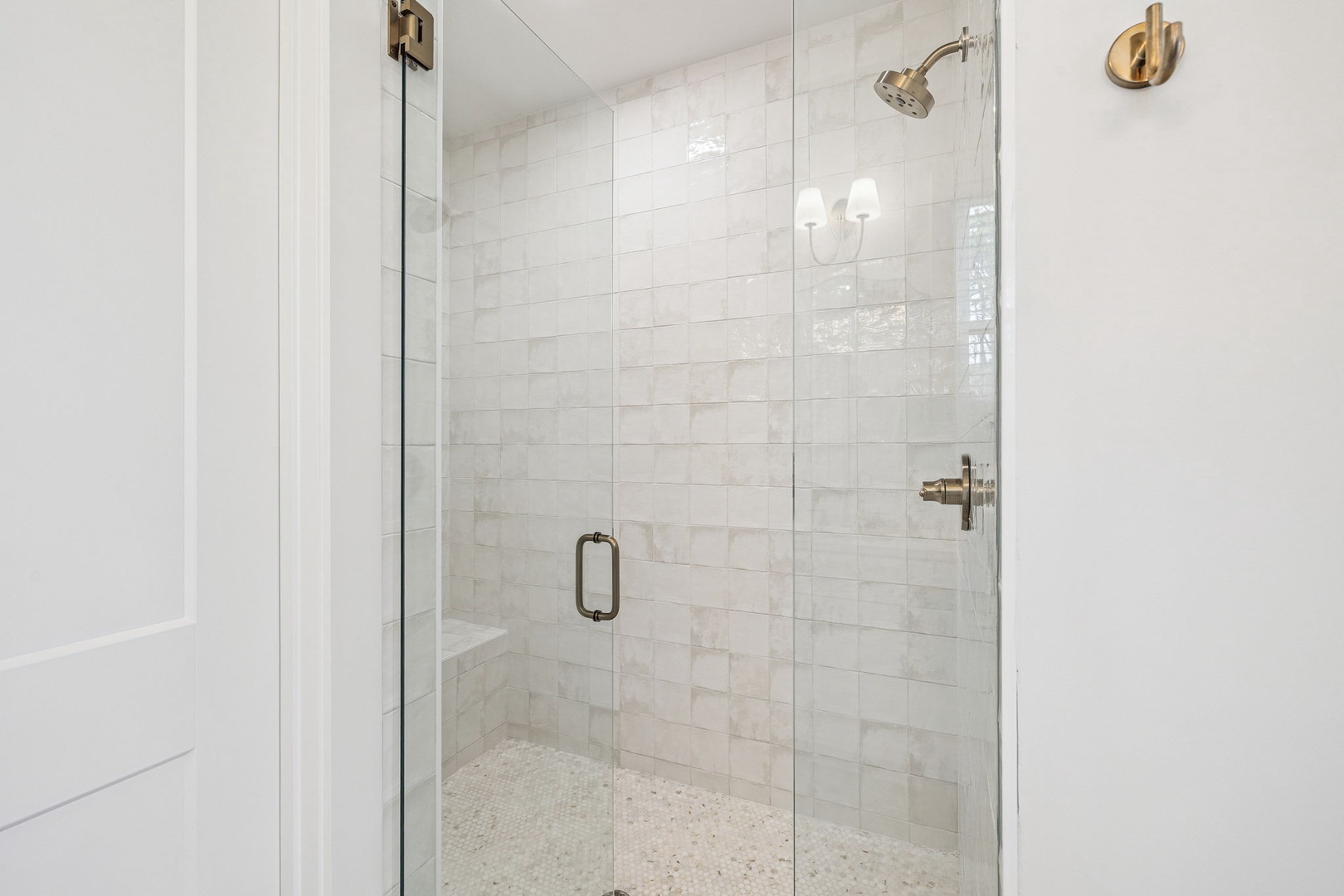 Step into your elegant glass-enclosed shower with luxurious marble tiles and brass fixtures for a spa-like experience.