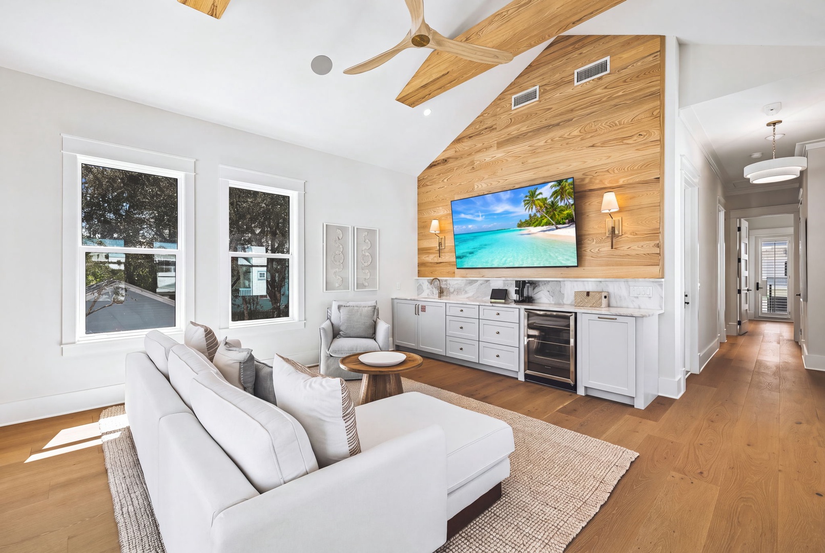 Unwind in your bright, airy living space featuring vaulted ceilings with natural wood beams, plush seating, and a cozy kitchenette perfect for preparing light refreshments during your stay.