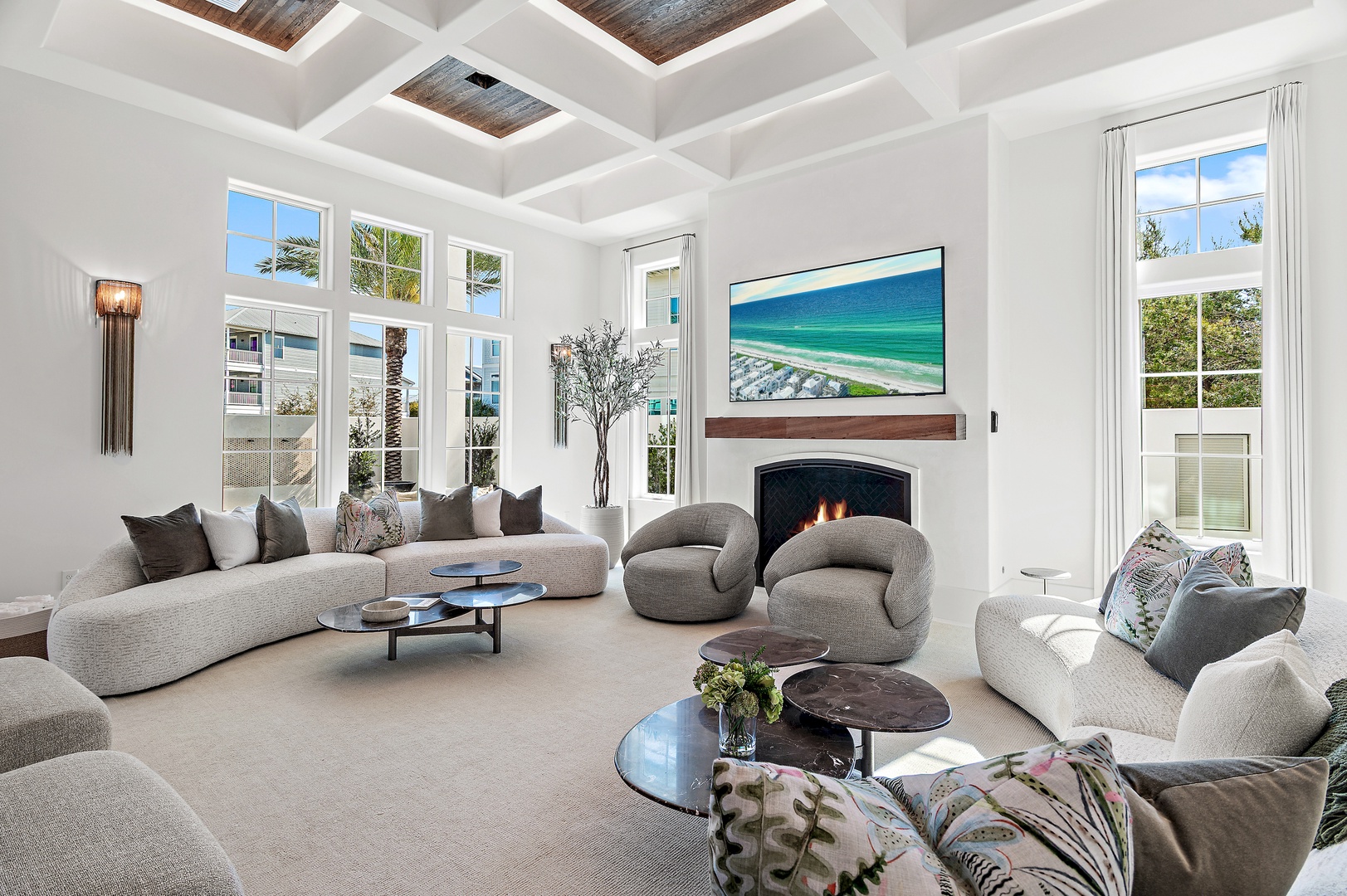 Sink into plush seating and let the coastal vibes surround you—this airy living room invites you to unwind by the fire with bright windows framing your retreat.