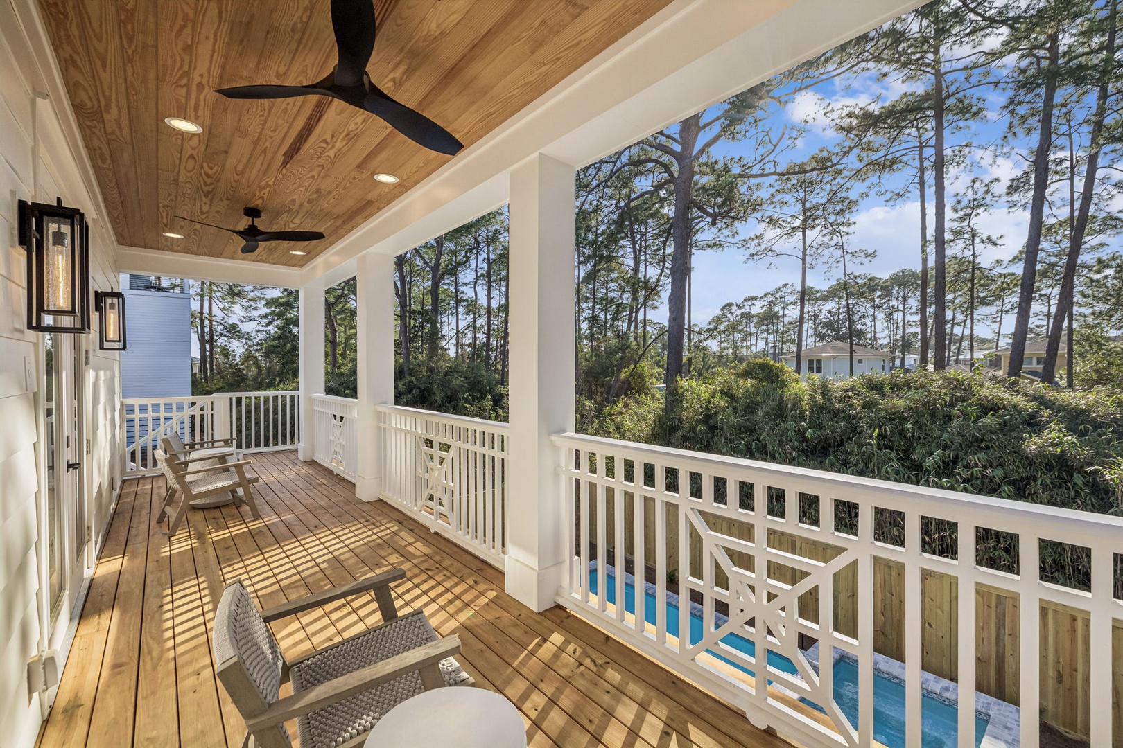 Relax on your private covered balcony with pool views and forest backdrop, where ceiling fans keep you cool while you unwind.