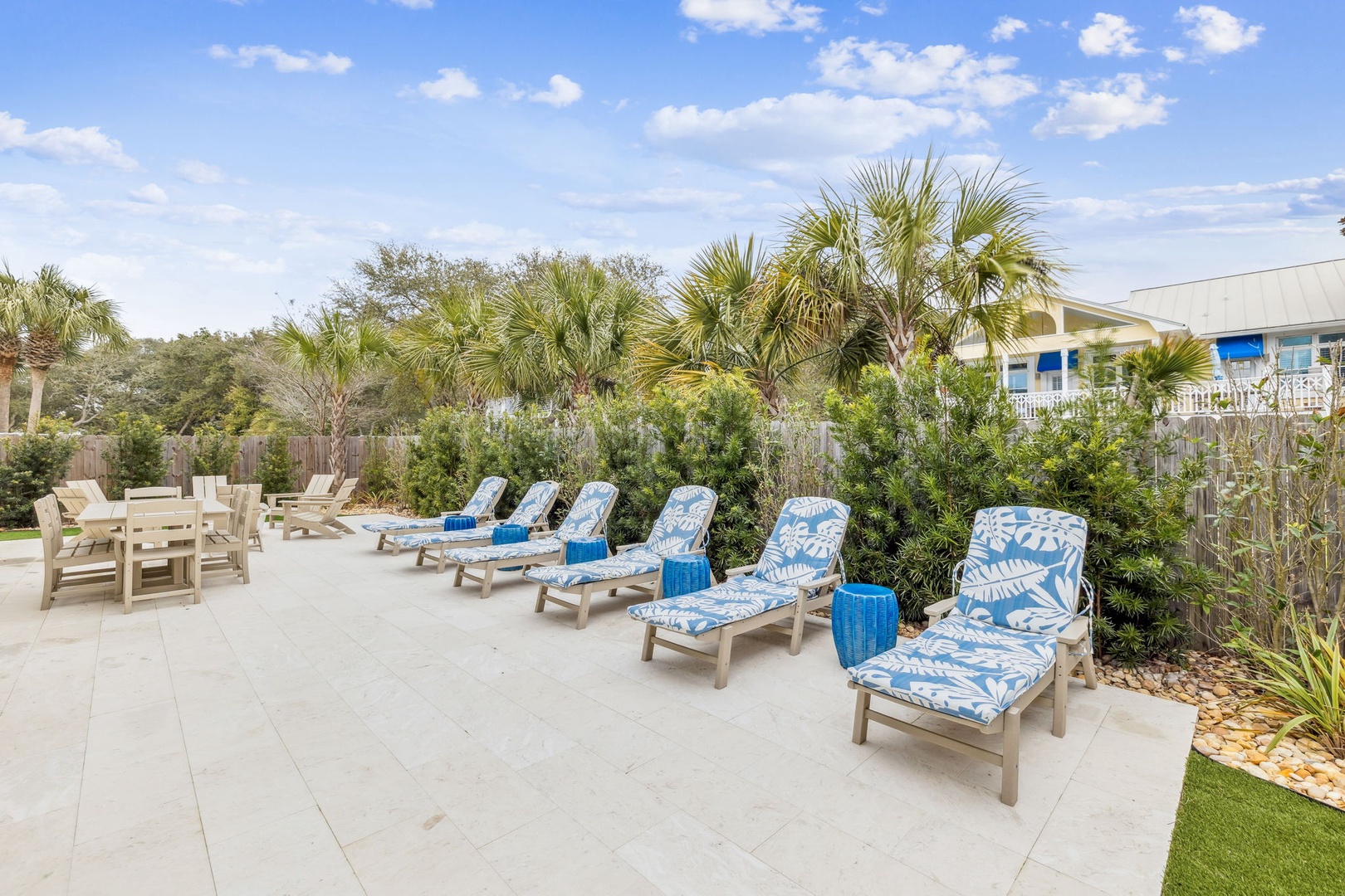 Soak up the sun on your private patio with comfortable loungers and tropical blue cushions surrounded by lush palms.