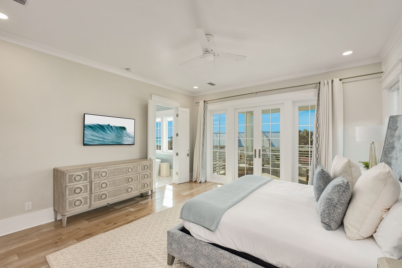Wake up to ocean breezes in this serene bedroom with its own balcony access and calming coastal decor.
