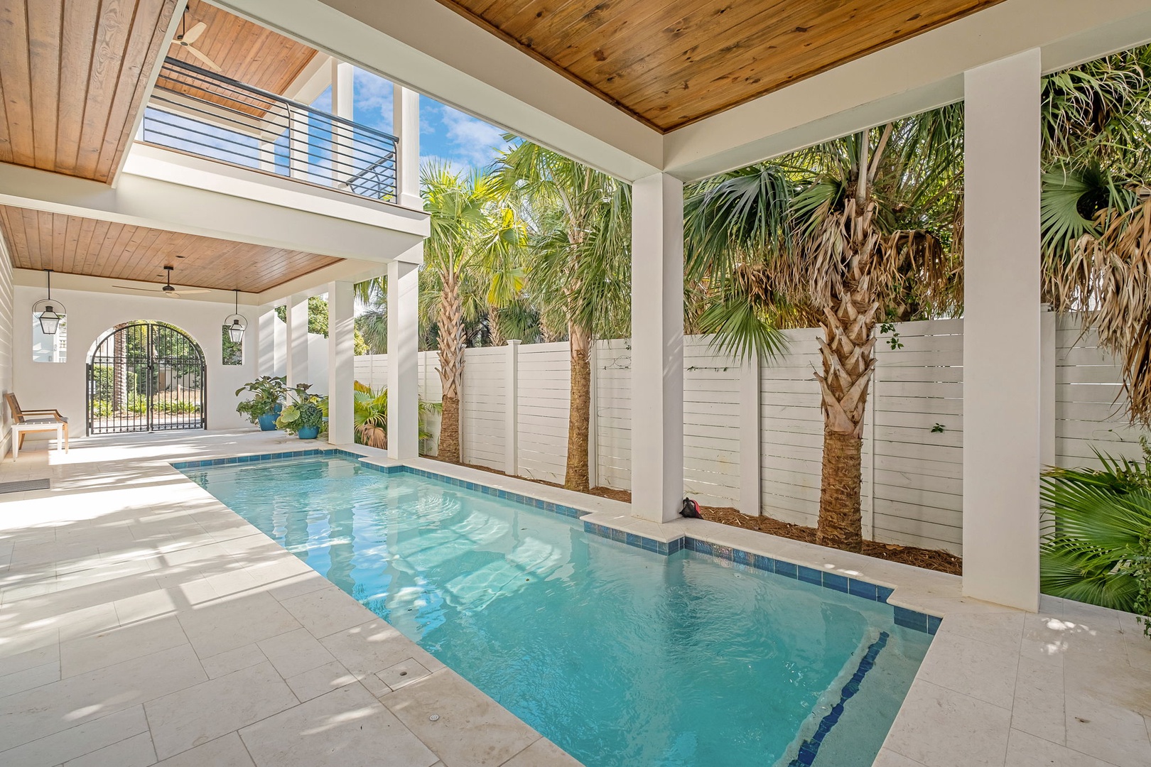 Your private tropical oasis awaits with crystal-clear water surrounded by swaying palms and elegant covered lounging areas.