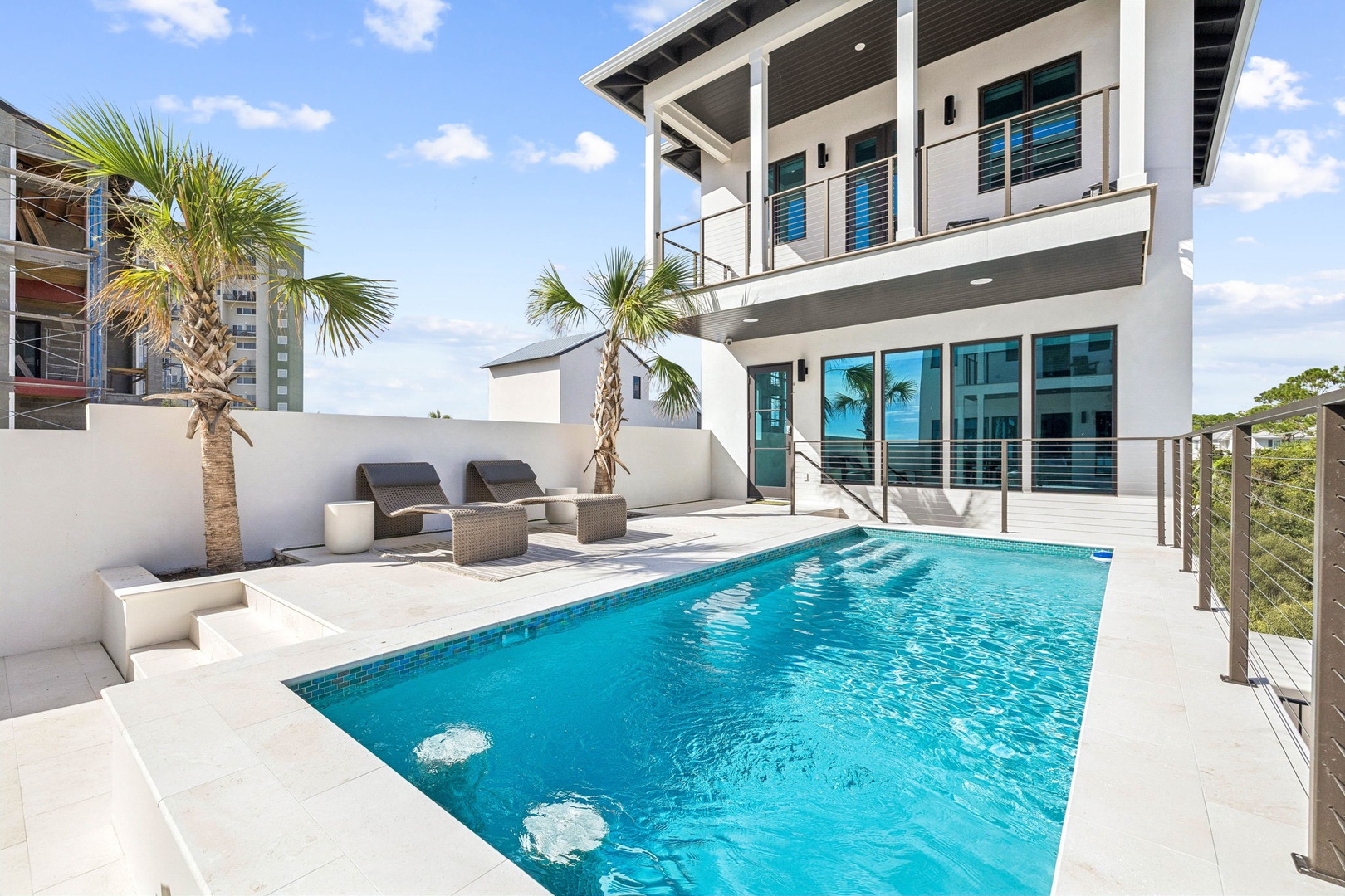 Dive into your private oasis—sparkling pool, sun loungers, and swaying palms create your perfect escape under endless blue skies.