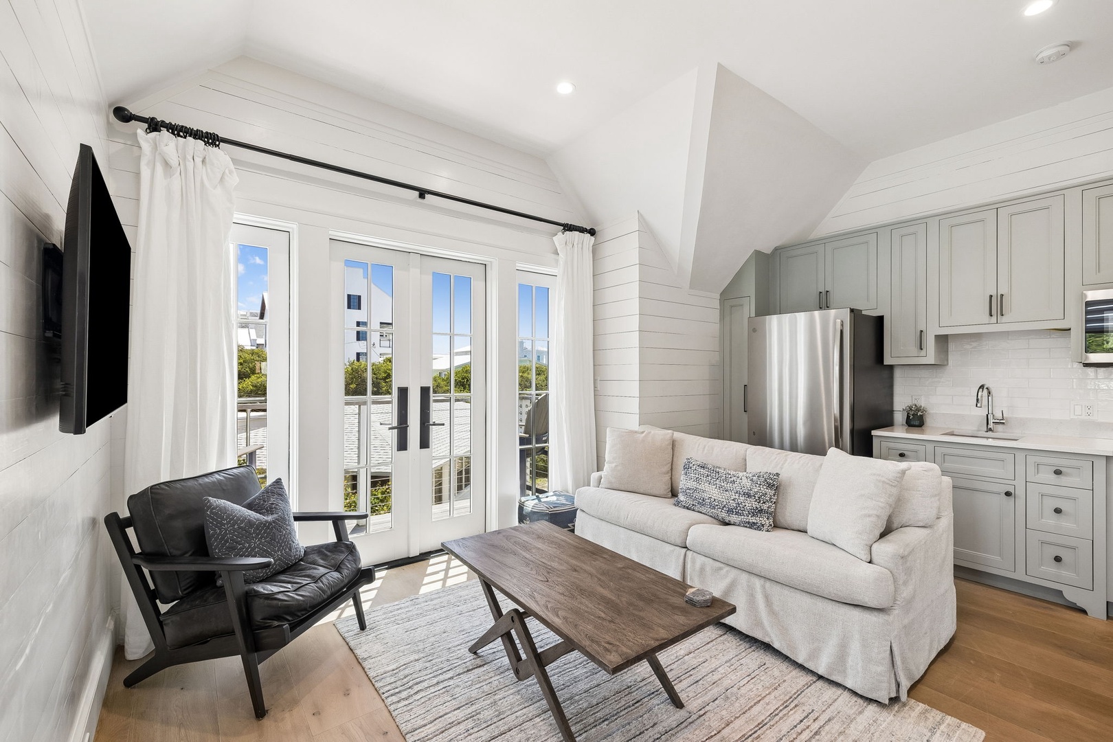 Relax in your open-concept living space with vaulted ceilings and sunlit views. The fully equipped kitchen, cozy seating, and balcony access make it your perfect home away from home.