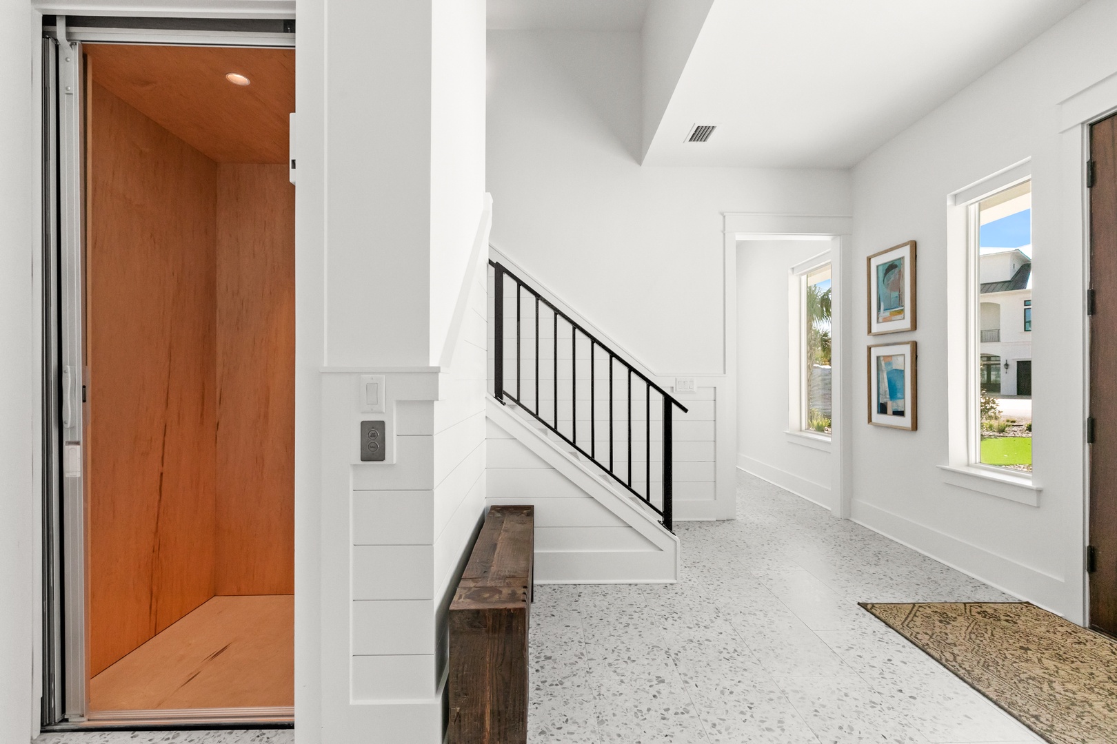 Step into a bright, open entryway with gleaming terrazzo floors, soaring ceilings, and natural light that welcomes you home. You'll love the airy feel and thoughtful design touches throughout.