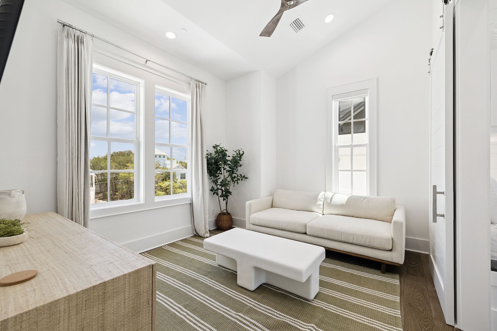 Sink into this bright living space where natural light floods through large windows, creating your perfect retreat for morning coffee or evening relaxation.