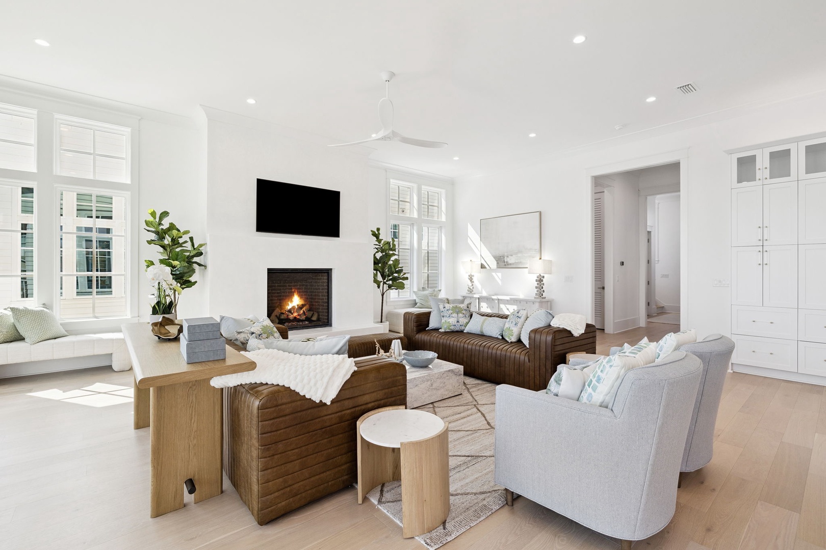 Unwind in your elegant living space featuring plush seating, a cozy fireplace, and abundant natural light for relaxing evenings.