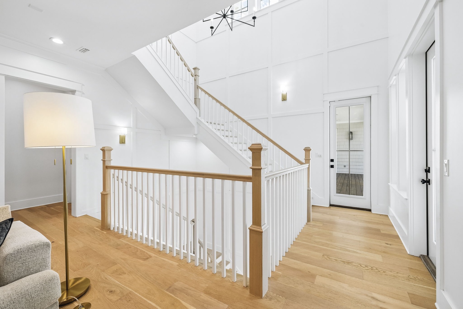 Bright, open entryway welcomes you home with soaring ceilings, warm wood floors, and elegant architectural details that set the tone for your entire stay.