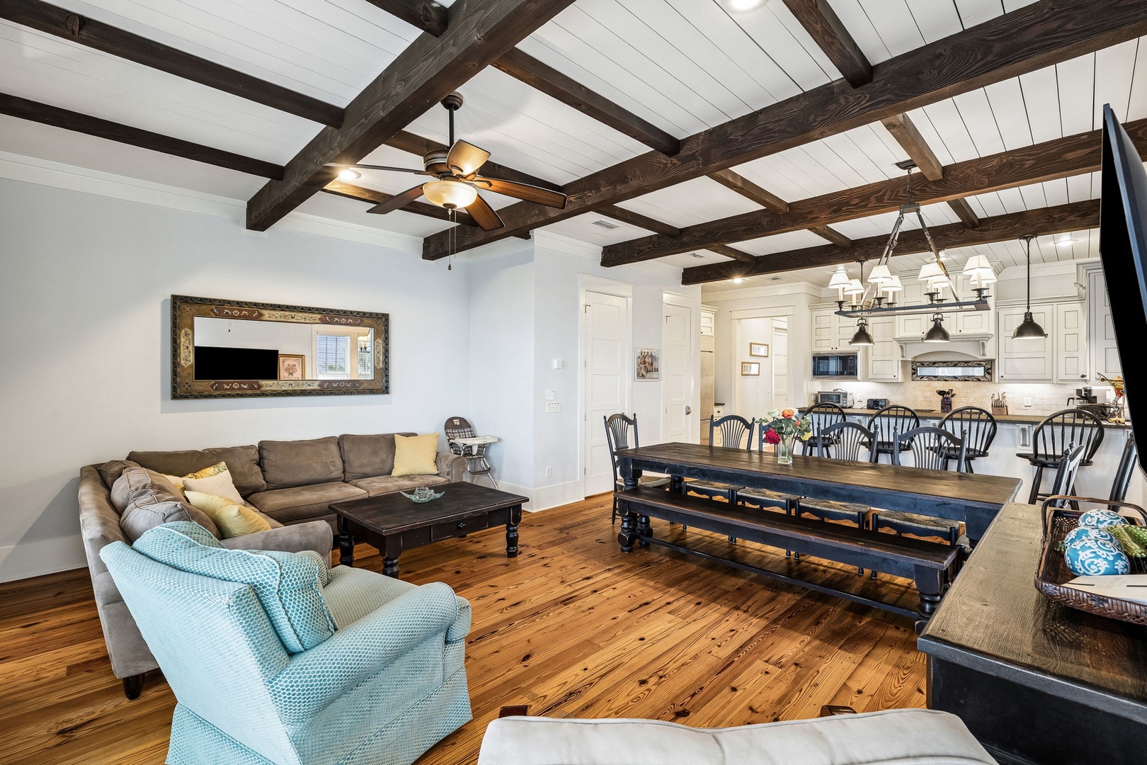 Unwind in this charming open-concept living and dining space with rustic exposed beams, warm wood floors, and plenty of room for your group to gather around the farmhouse-style table.