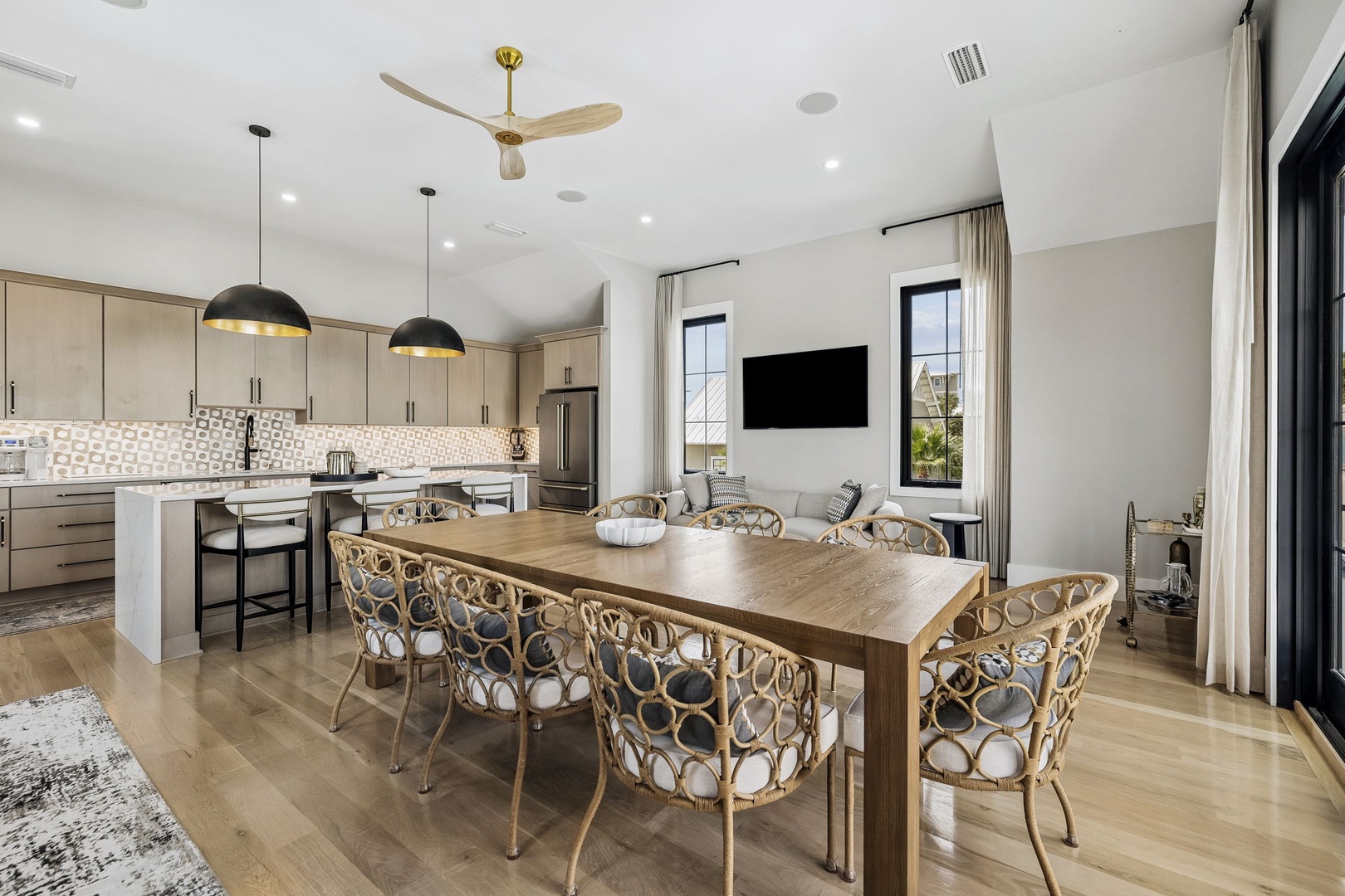 Gather around the large dining table where meals and memories await. The open kitchen and bright living space flow together seamlessly, inviting you to relax in airy comfort beneath soaring ceilings.