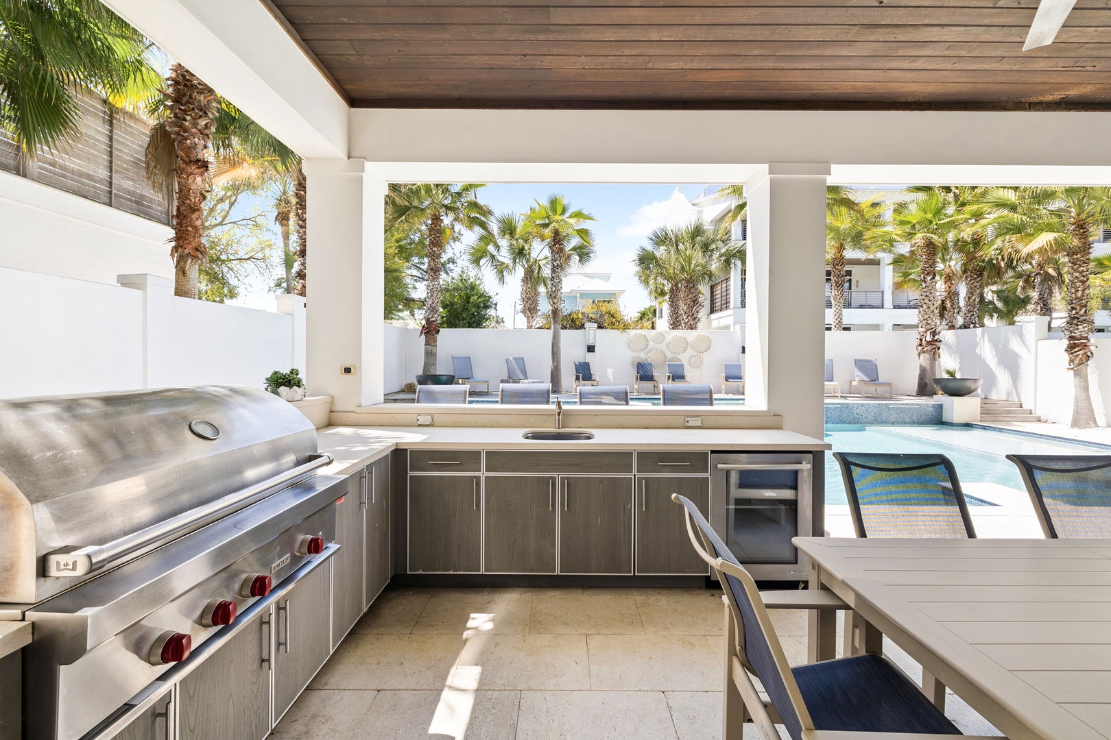 Your outdoor kitchen overlooks the pool, perfect for preparing meals while staying connected to the fun.