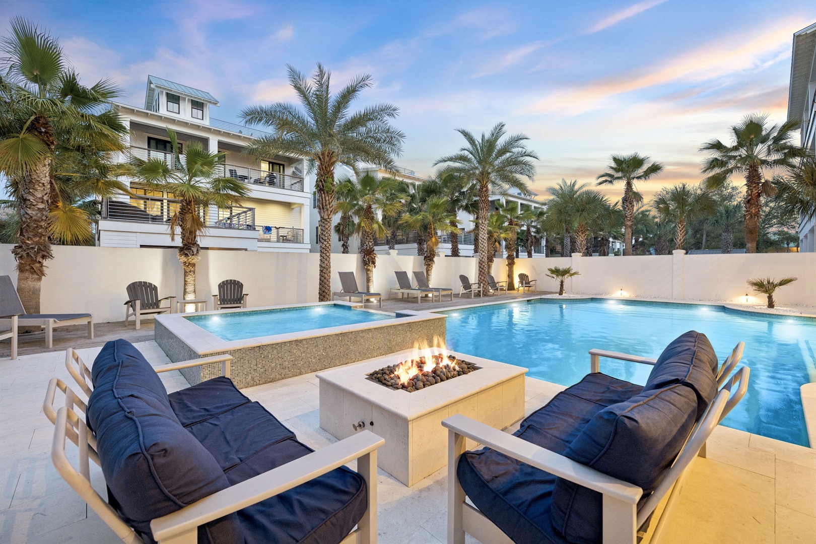 Luxurious poolside paradise with fire pit seating, where evening relaxation meets tropical elegance under swaying palms and endless sky.