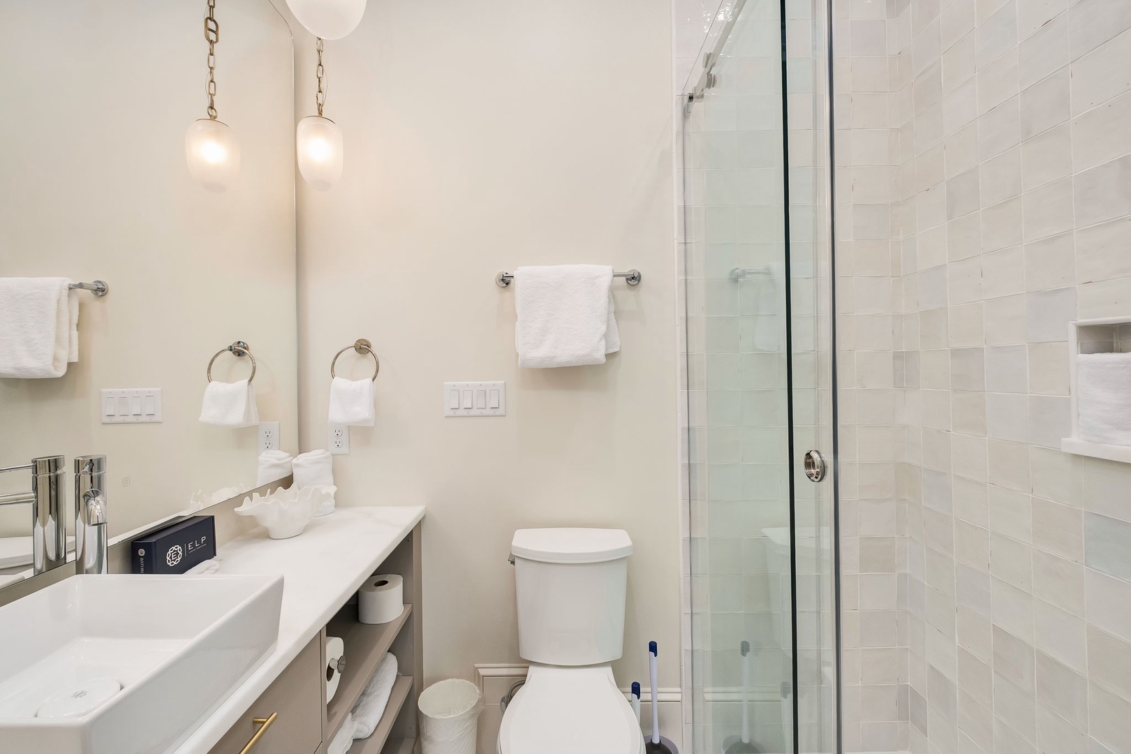 Unwind in a bright, modern bathroom with soft lighting, fresh towels, and a sleek glass-enclosed shower ready for your refresh after a day exploring.
