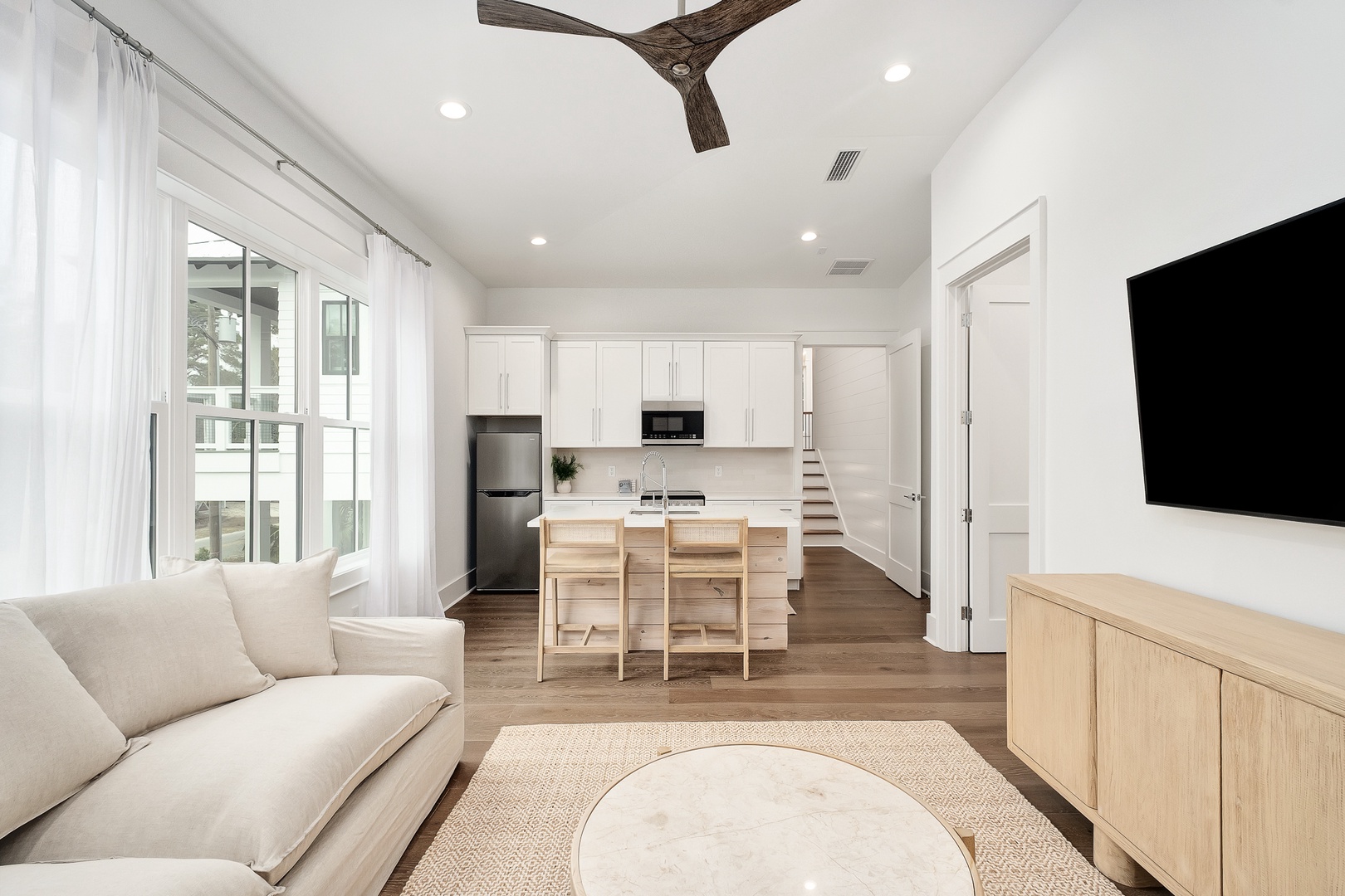 Unwind in your bright, modern space featuring exposed beams, cozy seating, and a fully equipped kitchen for home-cooked meals.