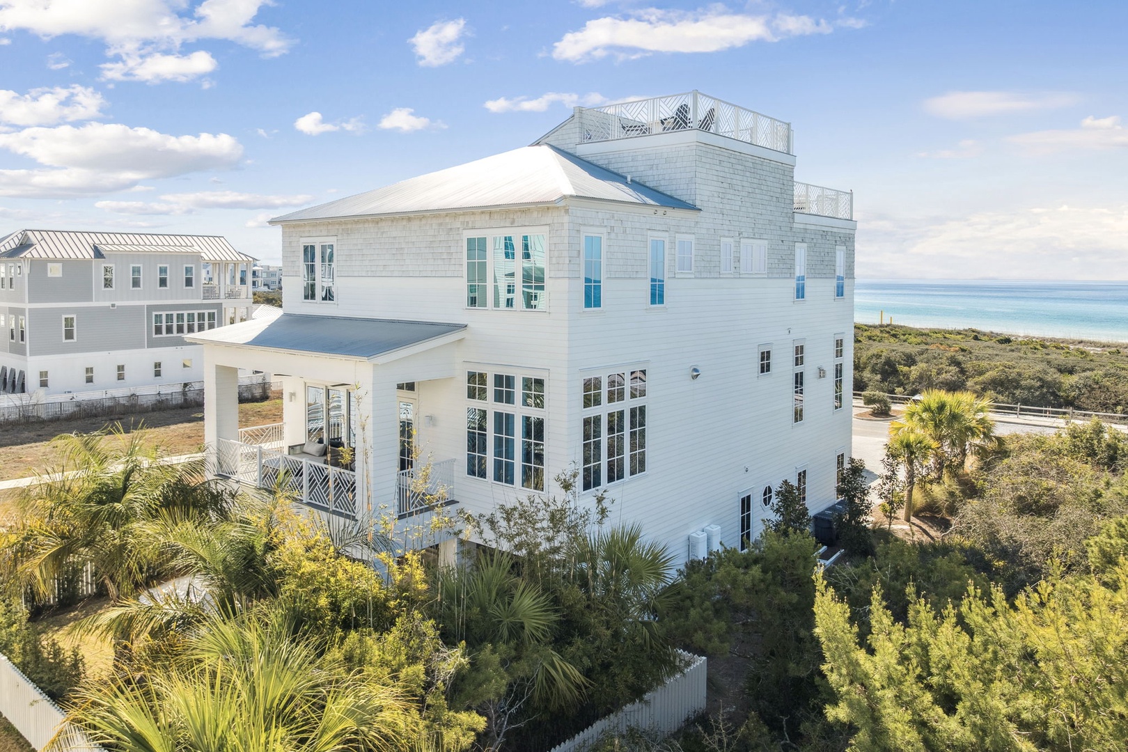 Elegant coastal home with rooftop deck overlooking pristine beaches and turquoise waters in a peaceful residential area.