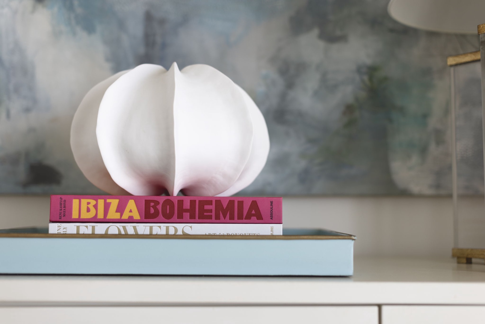 Chic sculptural lamp and curated books add artistic flair to your bedside, creating a refined atmosphere for unwinding after exploring the island.