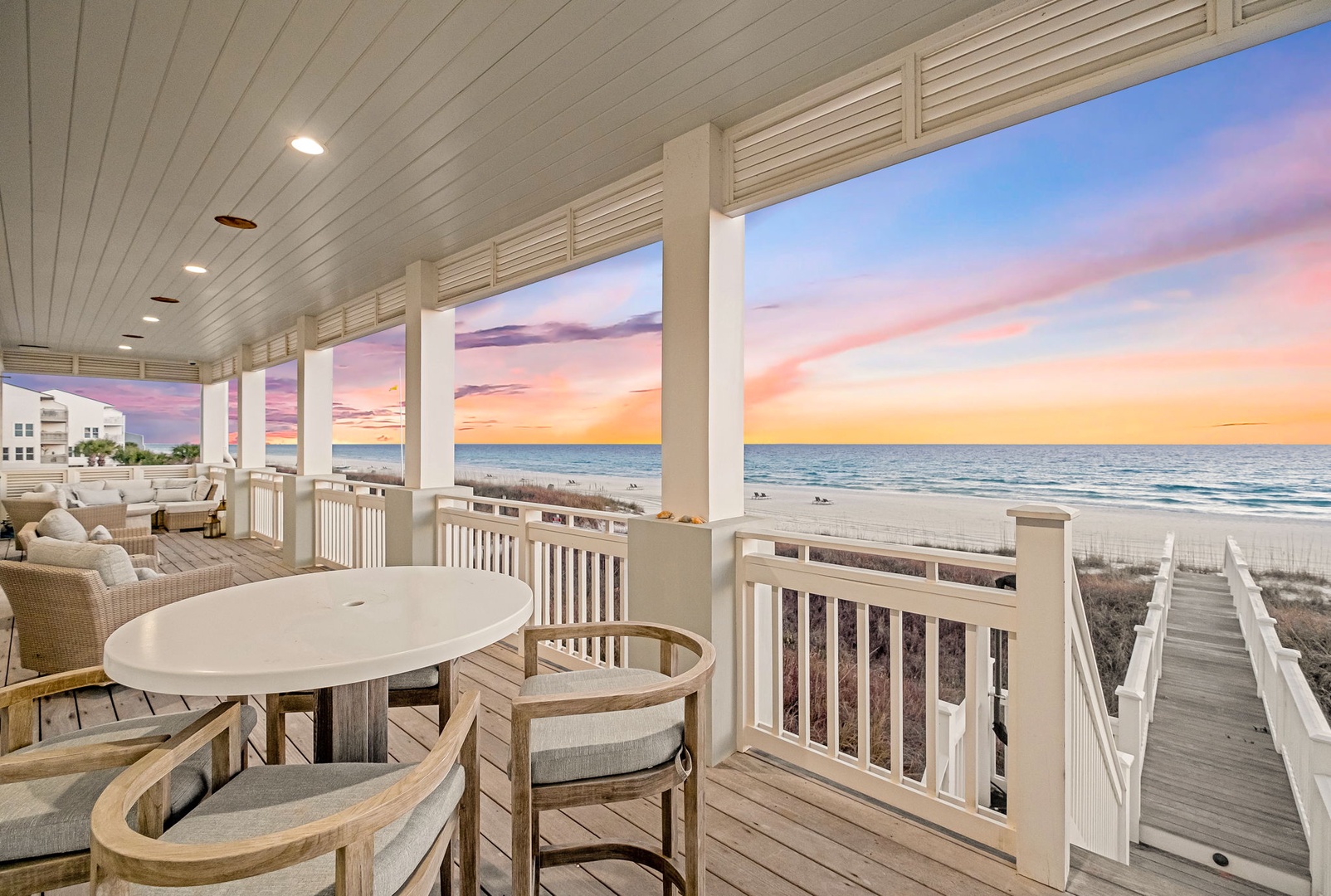 Beachfront deck with sweeping ocean views and private boardwalk access. Watch the sky transform into pastel hues from your inviting coastal retreat.