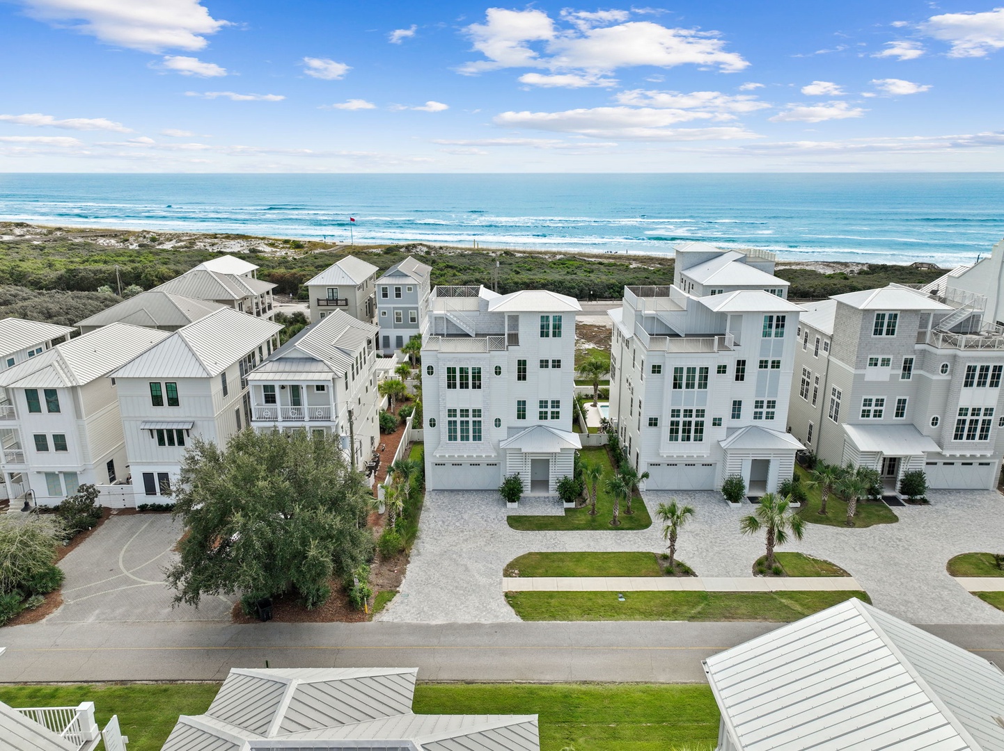 Aerial view of beachfront vacation rental community featuring modern coastal homes with ocean access and pristine shoreline just steps away.