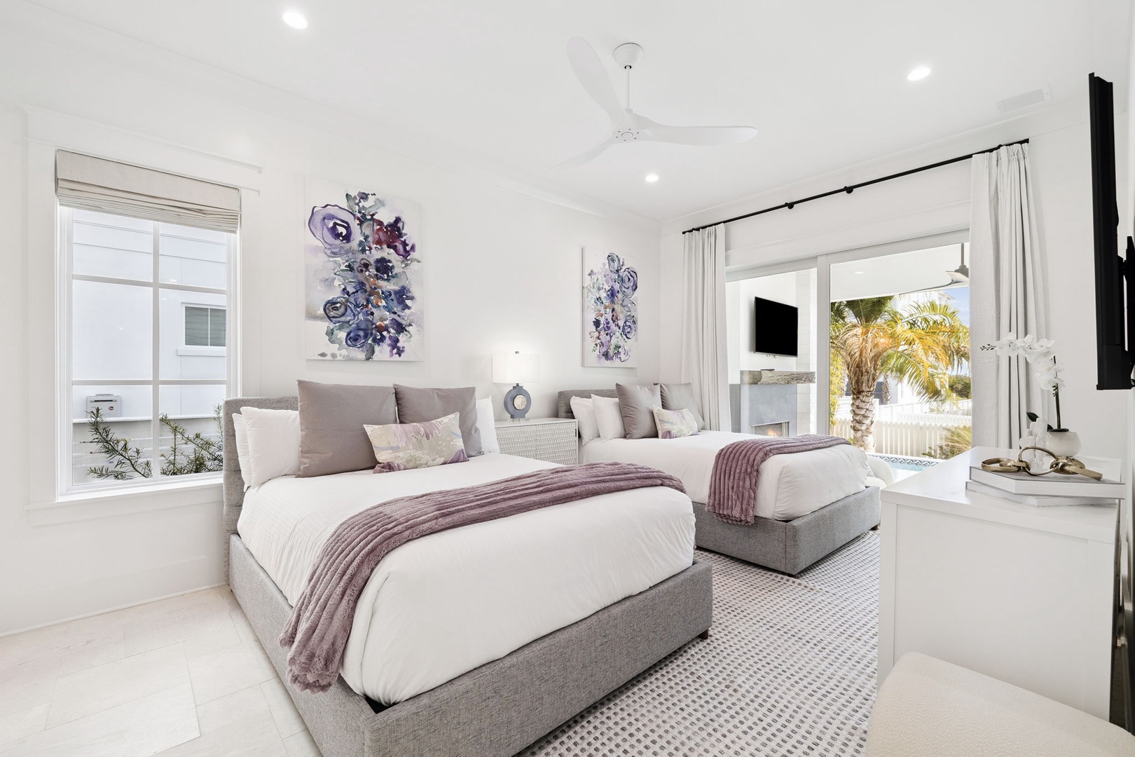 Drift off in this elegant twin bedroom with plush linens, tropical views, and serene purple artwork that creates your perfect retreat.