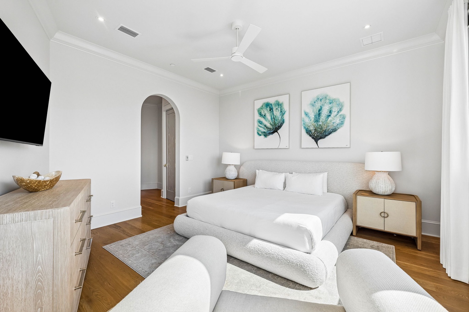 Unwind in your serene retreat with a plush bed, soothing coastal artwork, and soft seating. Ceiling fans keep you cool while warm wood floors add comfort underfoot.