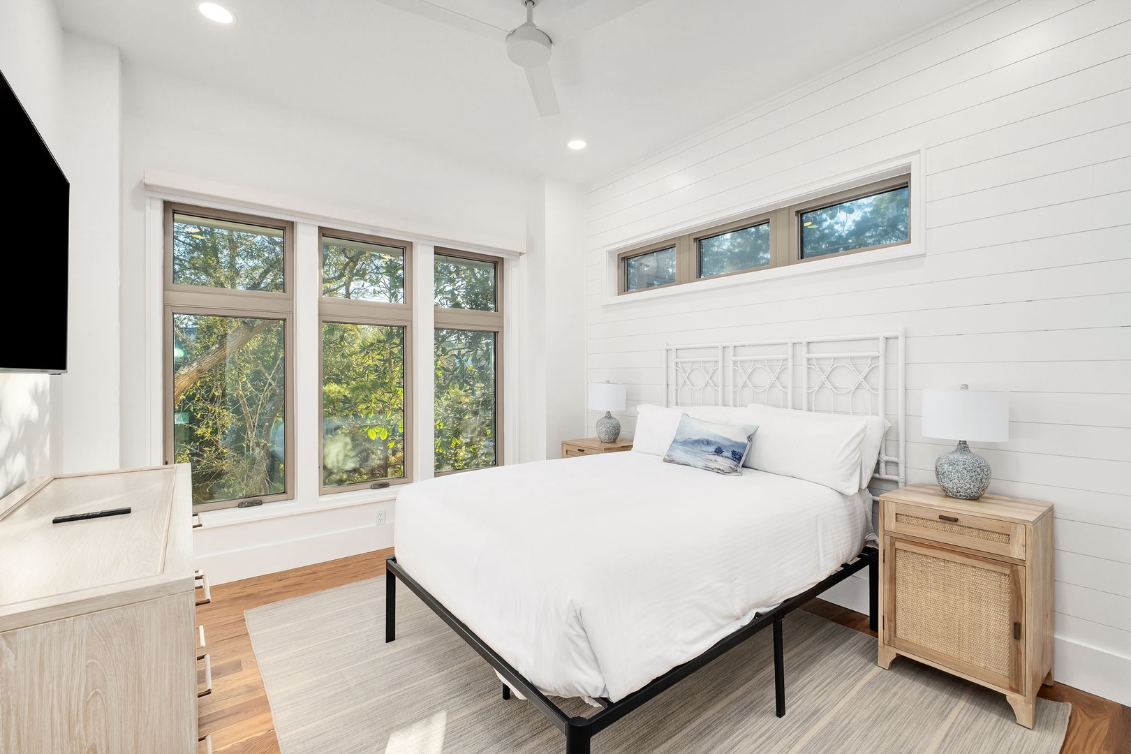 Drift off to sleep in your bright, airy bedroom with crisp white linens and peaceful garden views streaming through oversized windows.