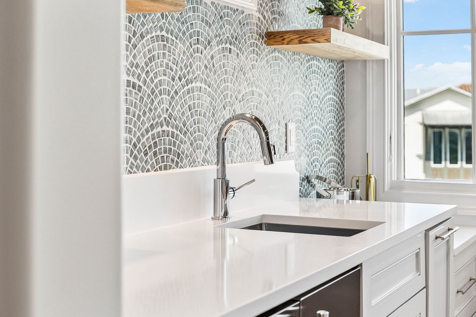 Step into your bright, modern kitchen featuring sleek white countertops, a chic mosaic tile backsplash, and natural light that makes cooking a joy.