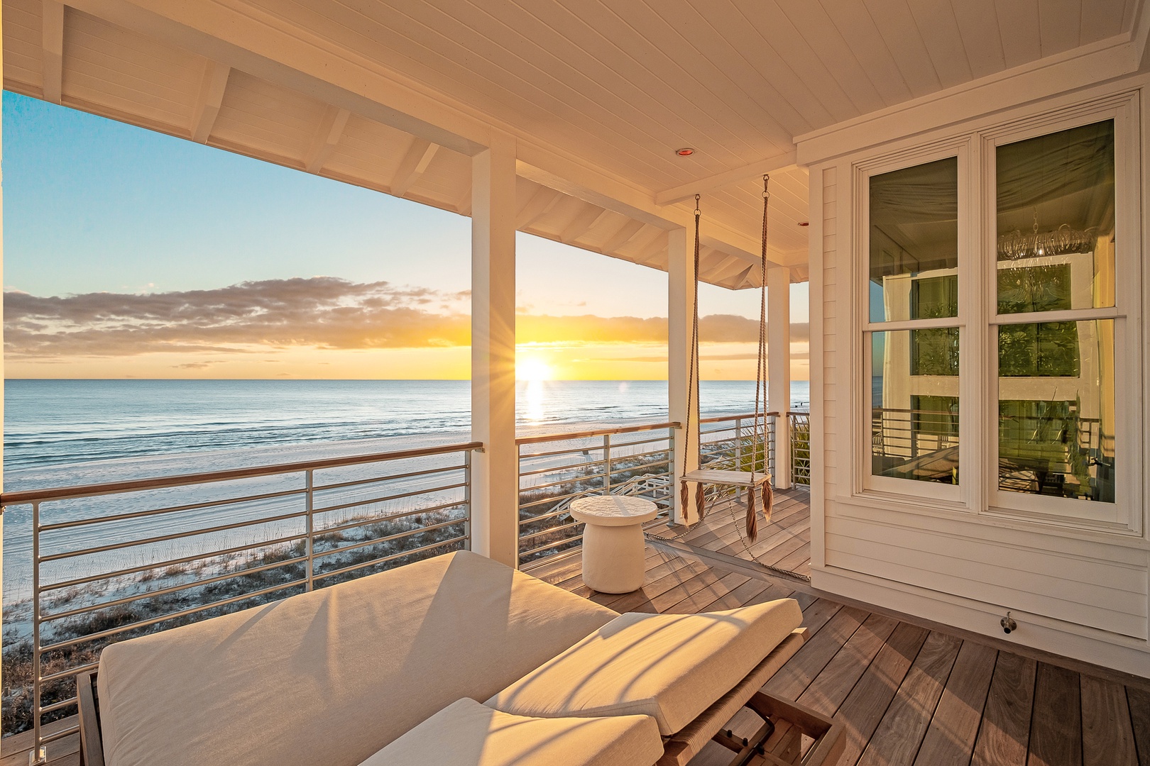 Oceanfront deck with breathtaking sunset views and peaceful swing seating.