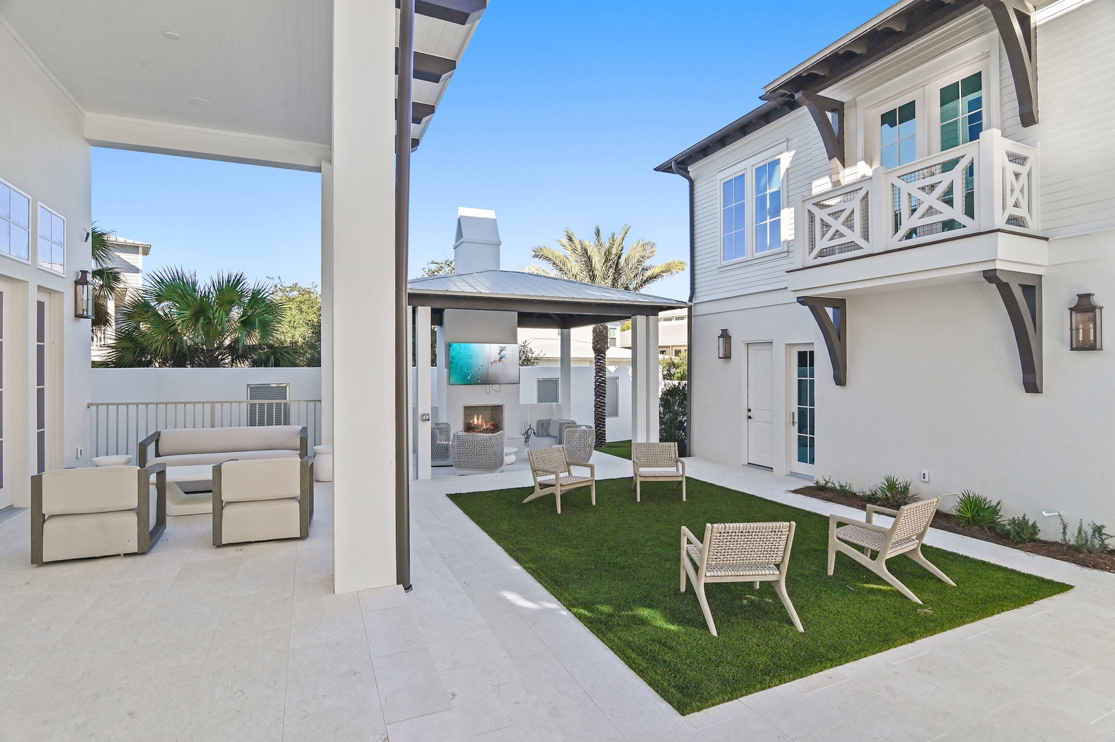 Step into your private courtyard retreat with lush green lawn, stylish seating, and a cozy fireplace—perfect for relaxing under sunny skies or gathering with loved ones in this peaceful outdoor sanctuary.