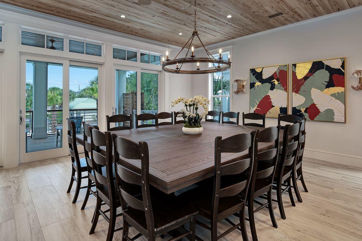 Gather around your spacious dining table where wood beams create warmth overhead and tropical views frame memorable meals together.