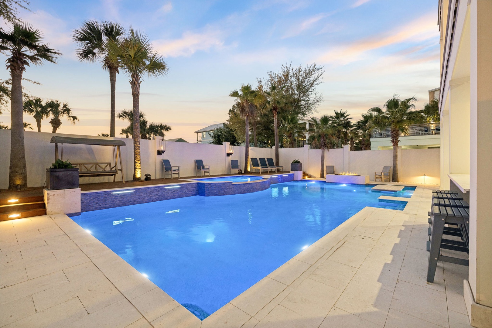 Unwind in your private tropical paradise as evening light dances across crystal-clear waters, surrounded by swaying palms and elegant poolside seating.