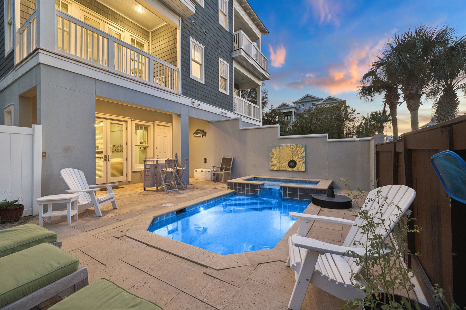 Warm coastal hues paint the sky as the day winds down, framing this inviting property and its private poolside retreat where your vacation memories begin.