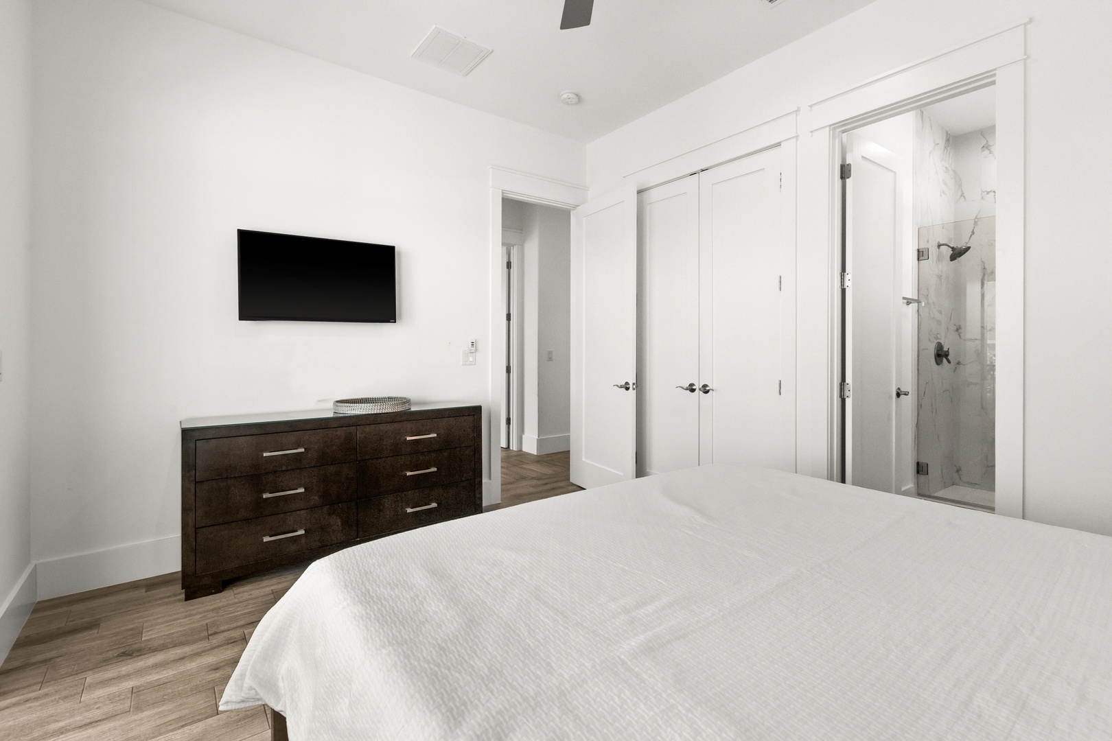 Unwind in your private retreat with a plush bed, sleek dresser, and an en-suite bath just steps away for ultimate convenience and relaxation.