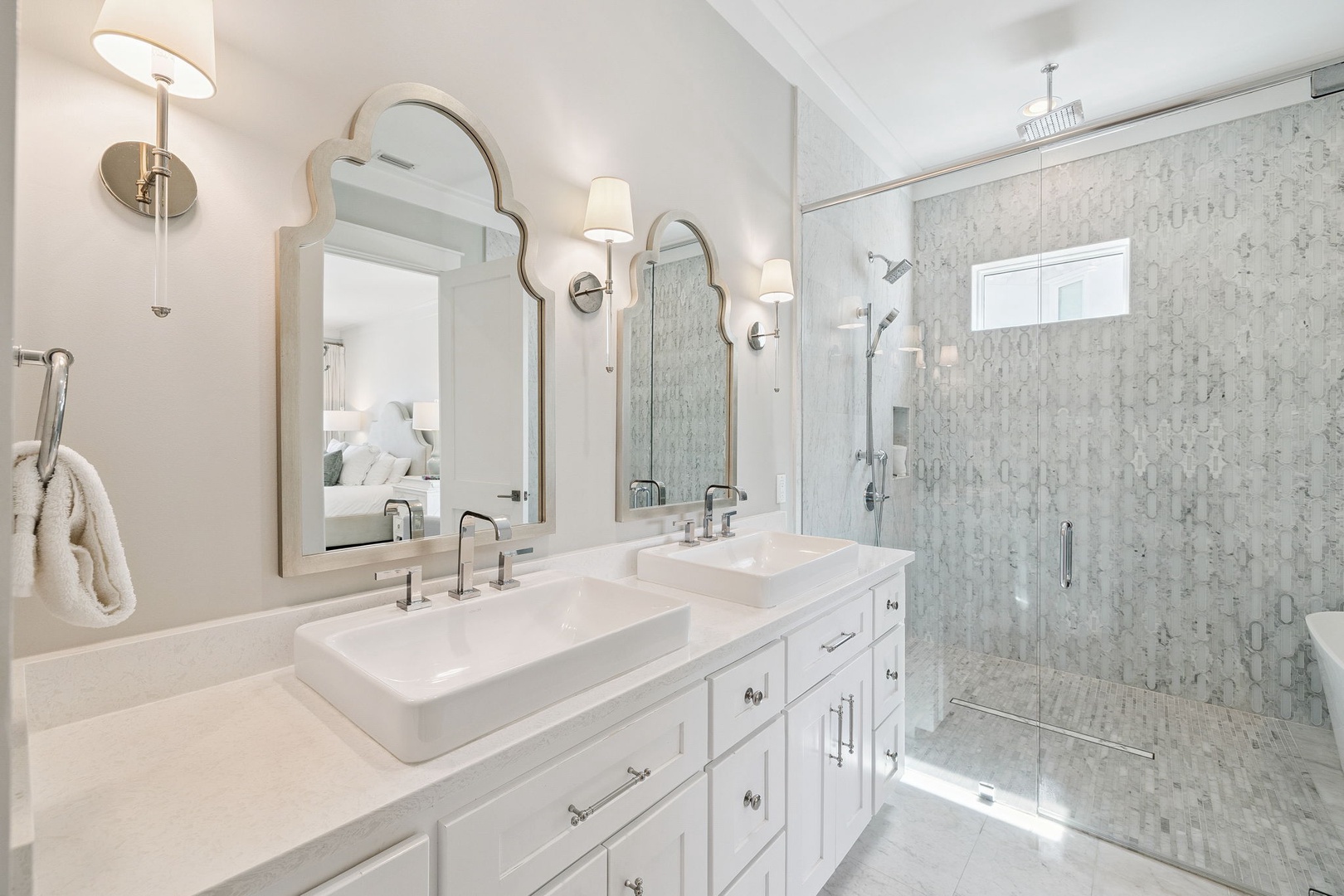 Indulge in your private spa-like retreat with elegant dual vanities, marble finishes, and a luxurious walk-in shower.
