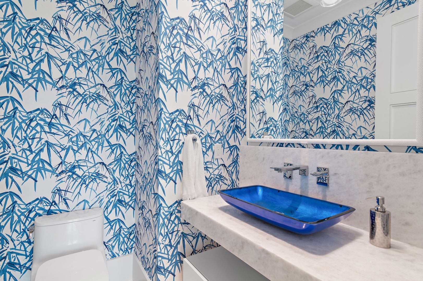 Step into your own private spa with vibrant blue bamboo wallpaper, a stunning sapphire basin, and sleek modern finishes that turn your daily routine into a luxurious escape.
