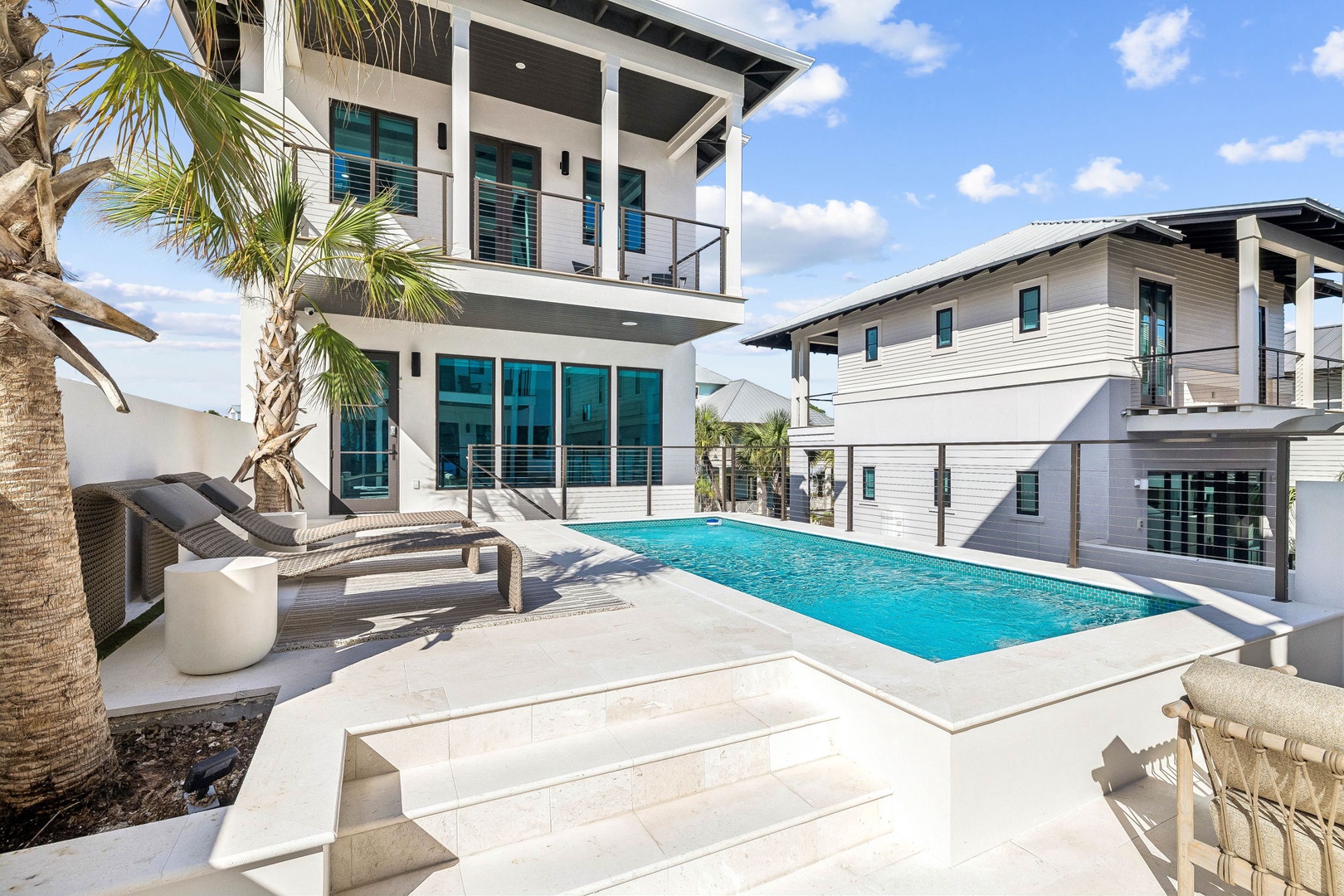 Your private oasis awaits—lounge poolside under swaying palms, soak up the sun on cushioned chairs, and enjoy the sparkling blue water just steps from your door.
