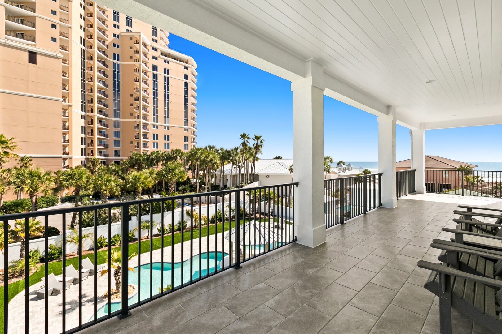 Step out onto your private balcony and take in stunning ocean and pool views, framed by swaying palms and blue skies—your perfect spot to unwind.