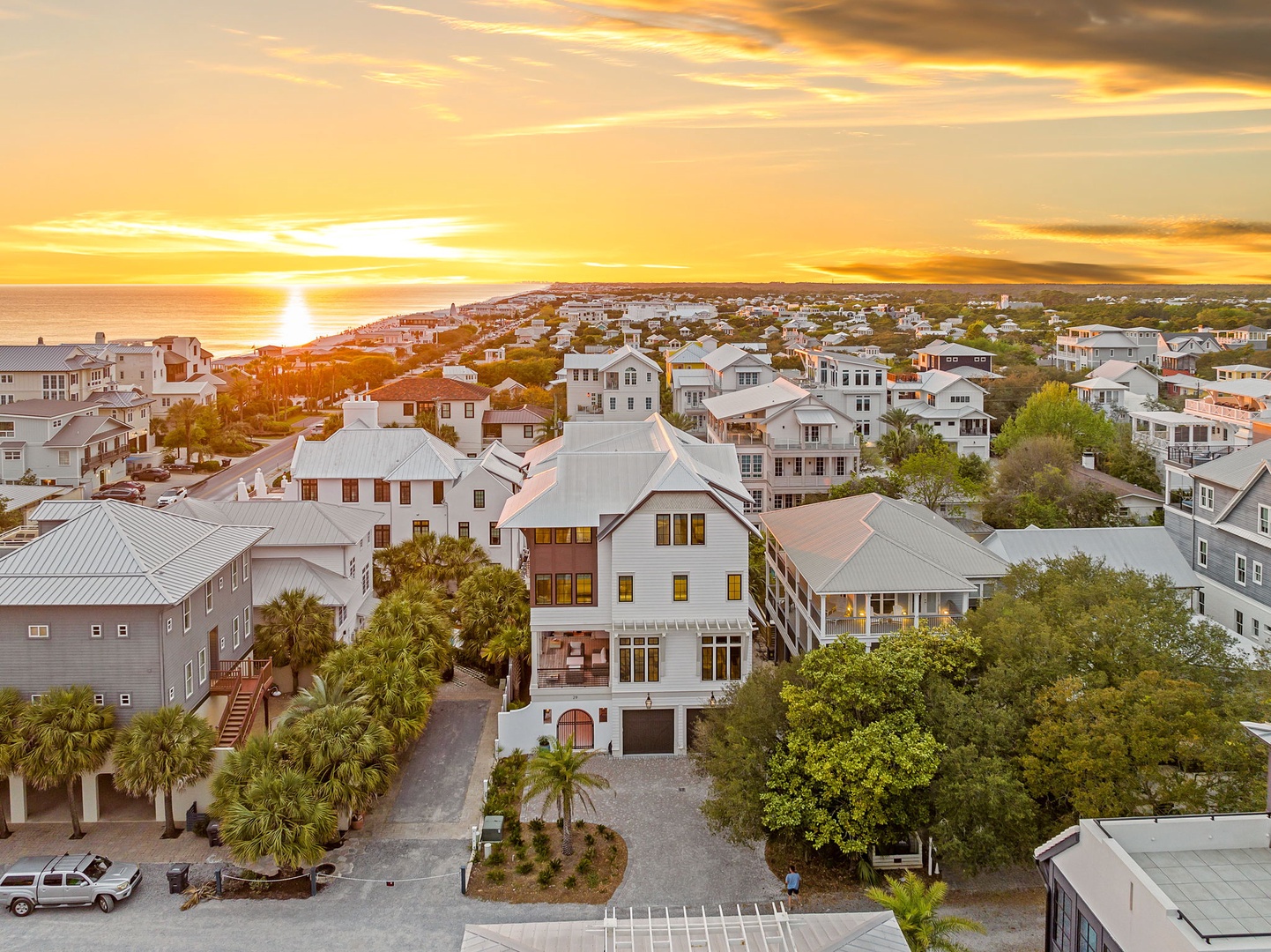 Stunning aerial view of a coastal community with elegant homes nestled among lush tropical landscaping, perfectly positioned near pristine beaches.