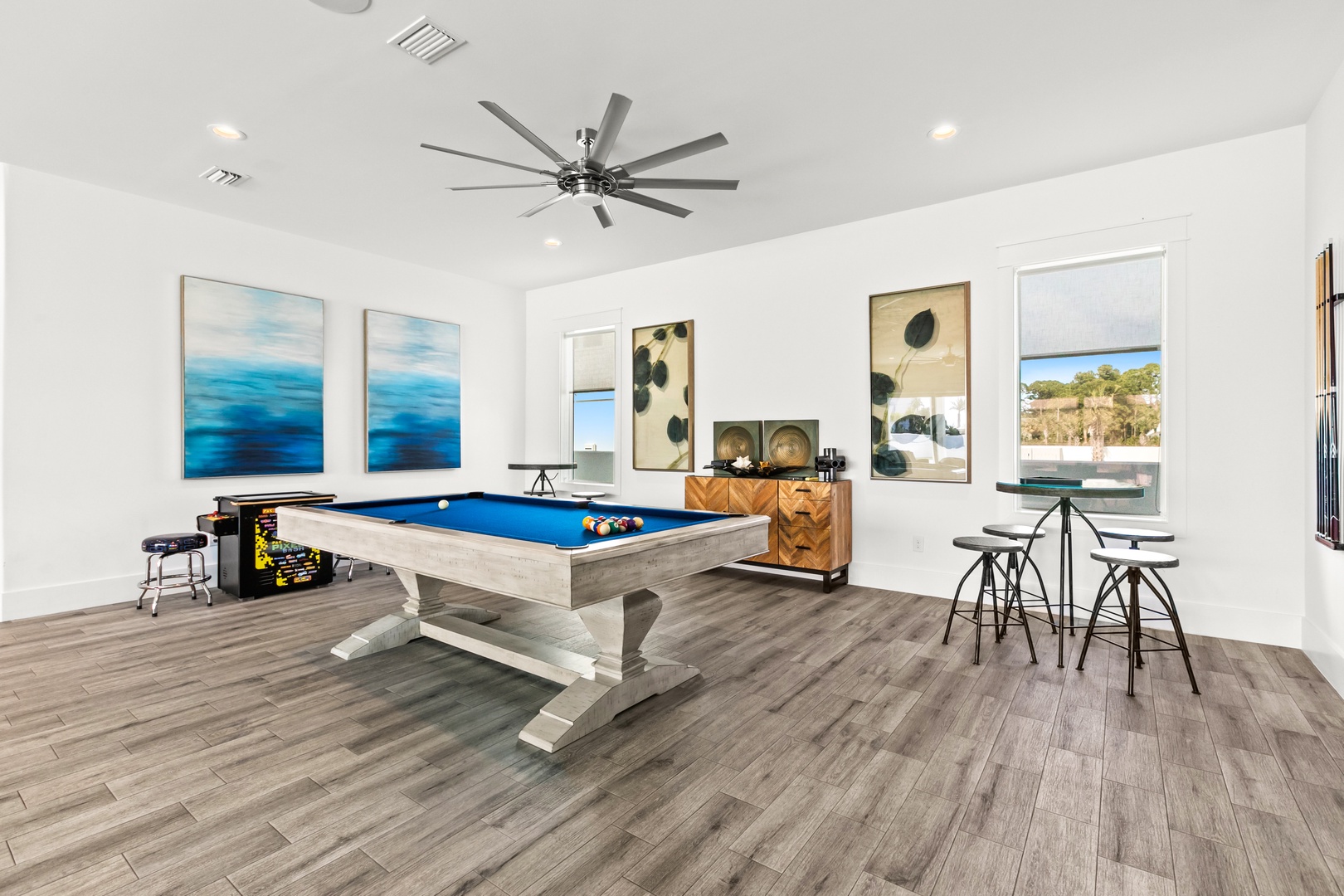 Unwind in your private game room, complete with a billiard table, arcade fun, and high-top seating for easy entertaining—all bathed in natural light.