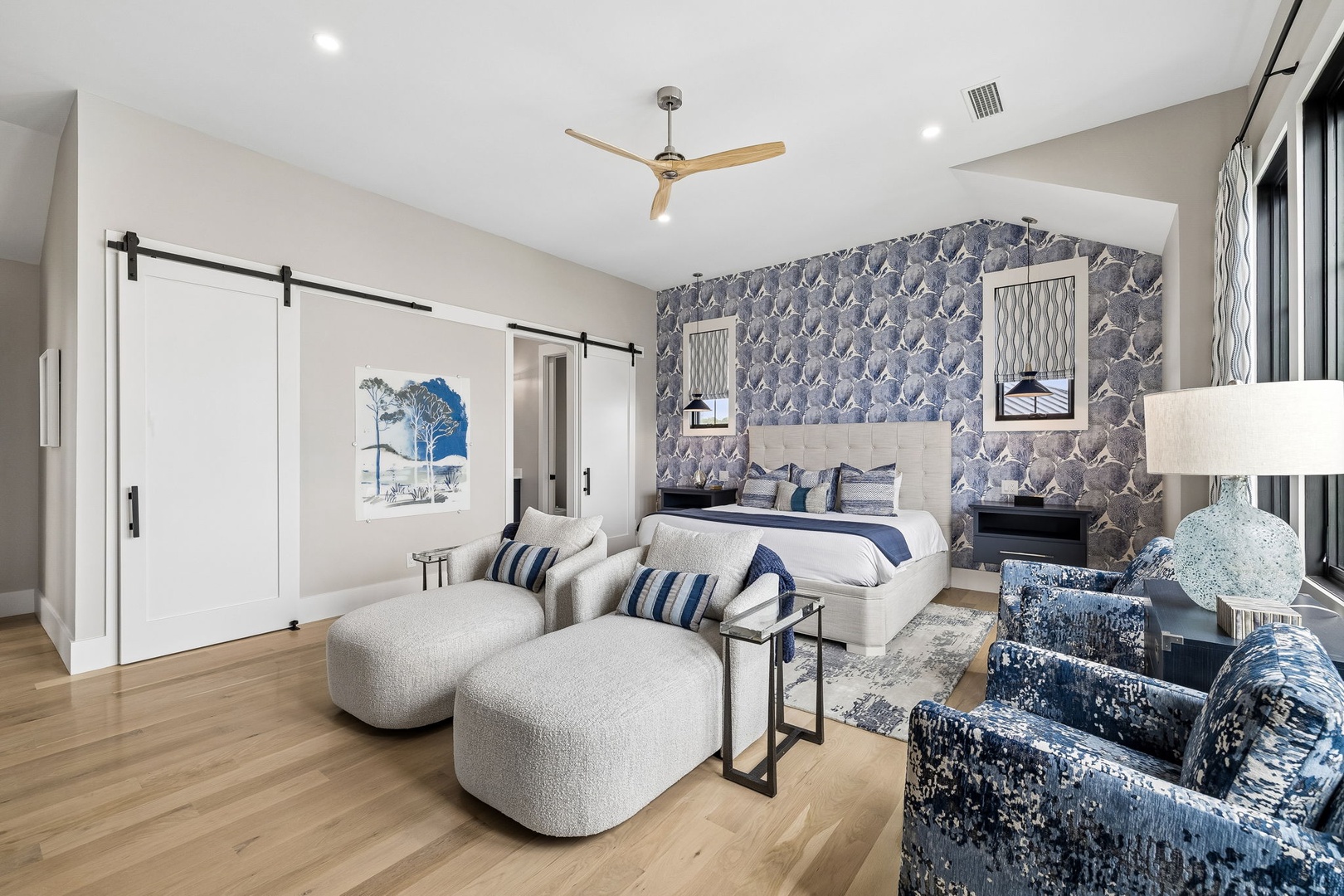 Sink into the plush seating and admire the stylish coastal-inspired wallpaper before unwinding in your king-sized sanctuary with elegant sliding barn doors and spa-like finishes.