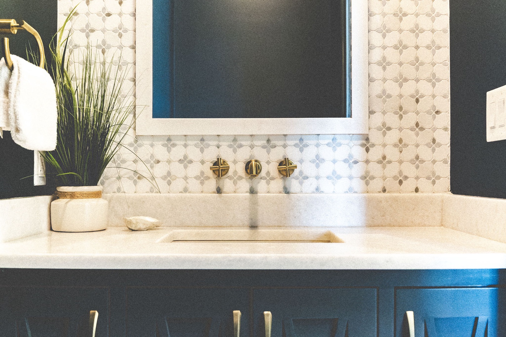 Refresh in style with elegant brass fixtures, chic patterned tile, and a sleek vanity designed for your comfort and ease.