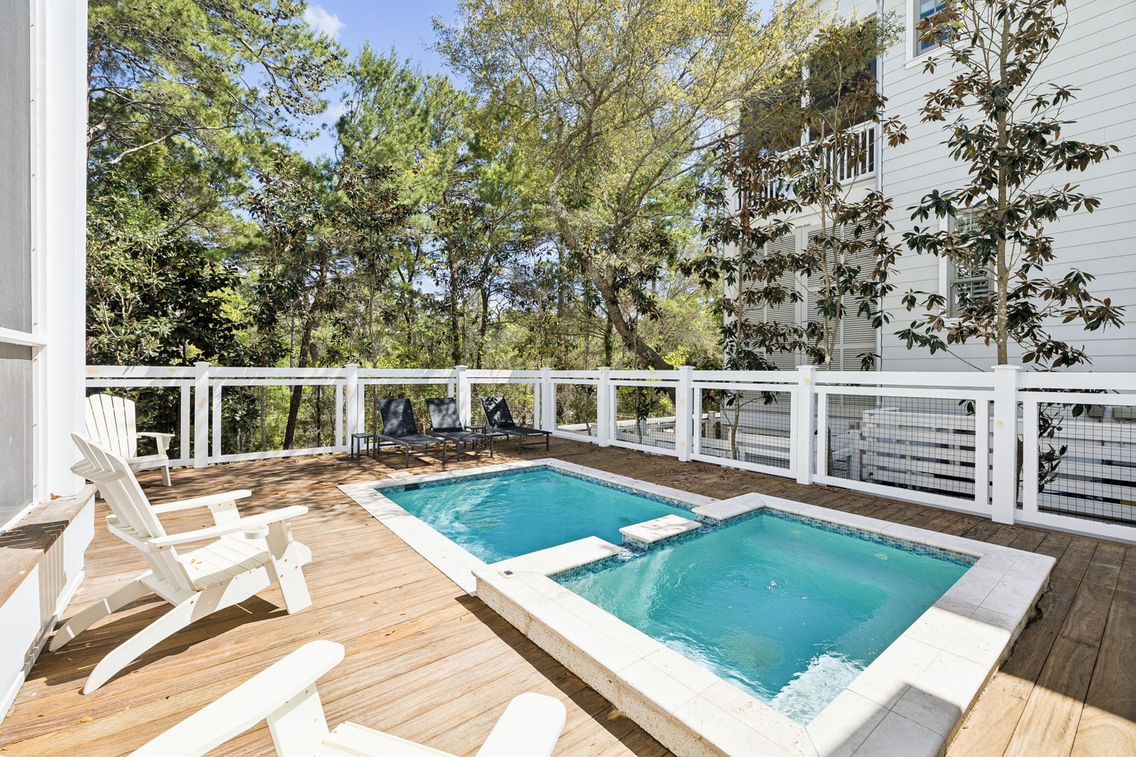 Unwind on your private deck with a refreshing pool and spa, surrounded by peaceful trees and comfortable loungers for ultimate relaxation.