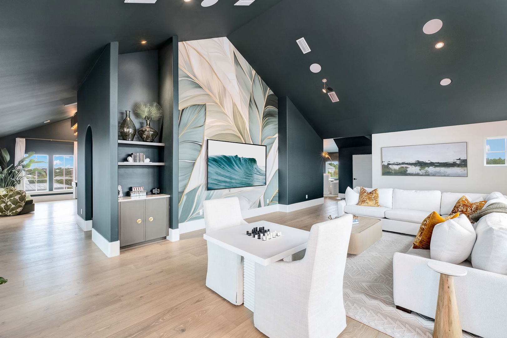 Relax in this stunning living space with soaring ceilings, elegant design, and artistic touches. Plush seating invites you to unwind while natural light streams through the windows, creating a bright and airy retreat.