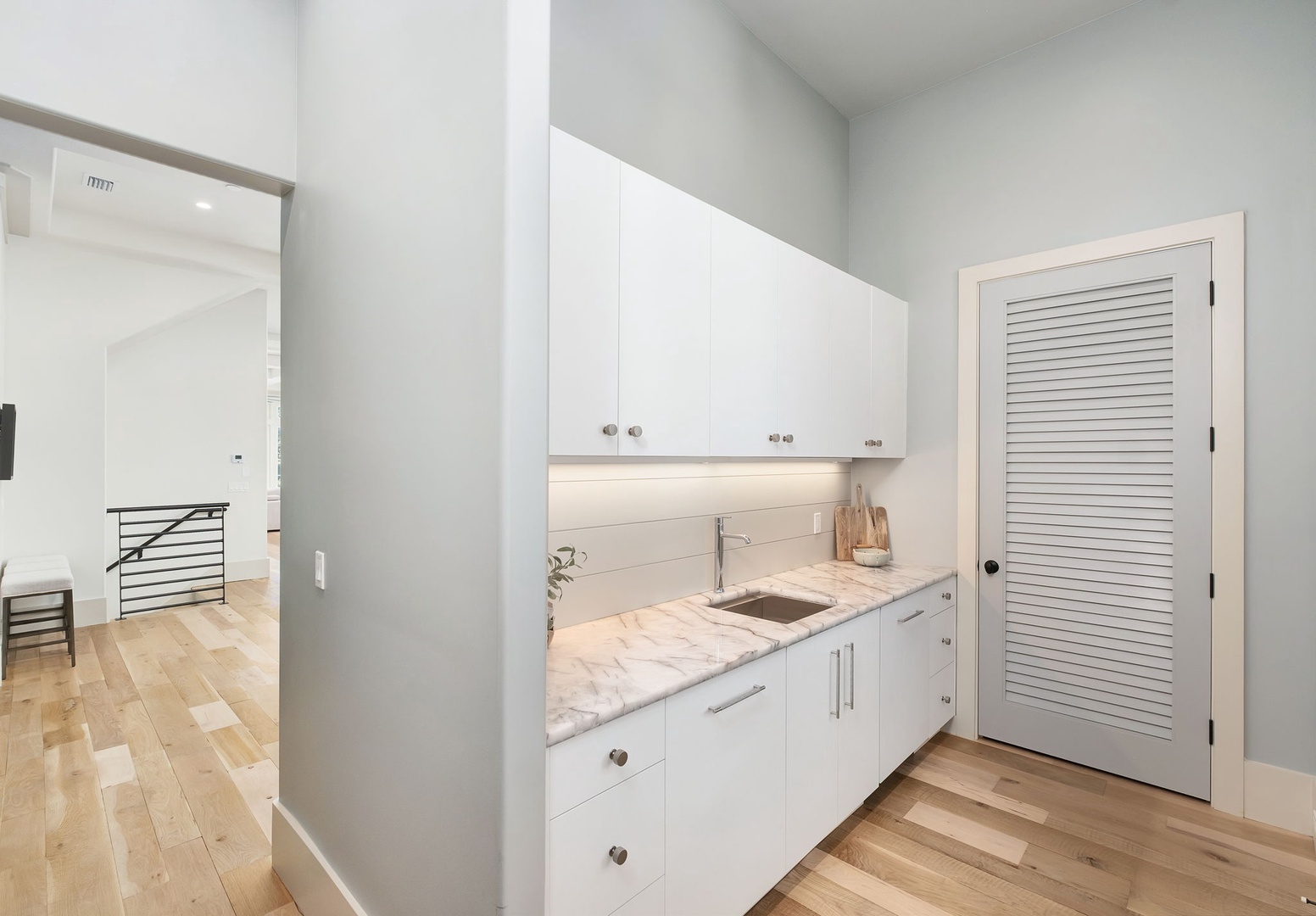 Your private kitchenette features pristine white cabinetry and marble countertops, perfect for preparing morning coffee or light meals in comfort.