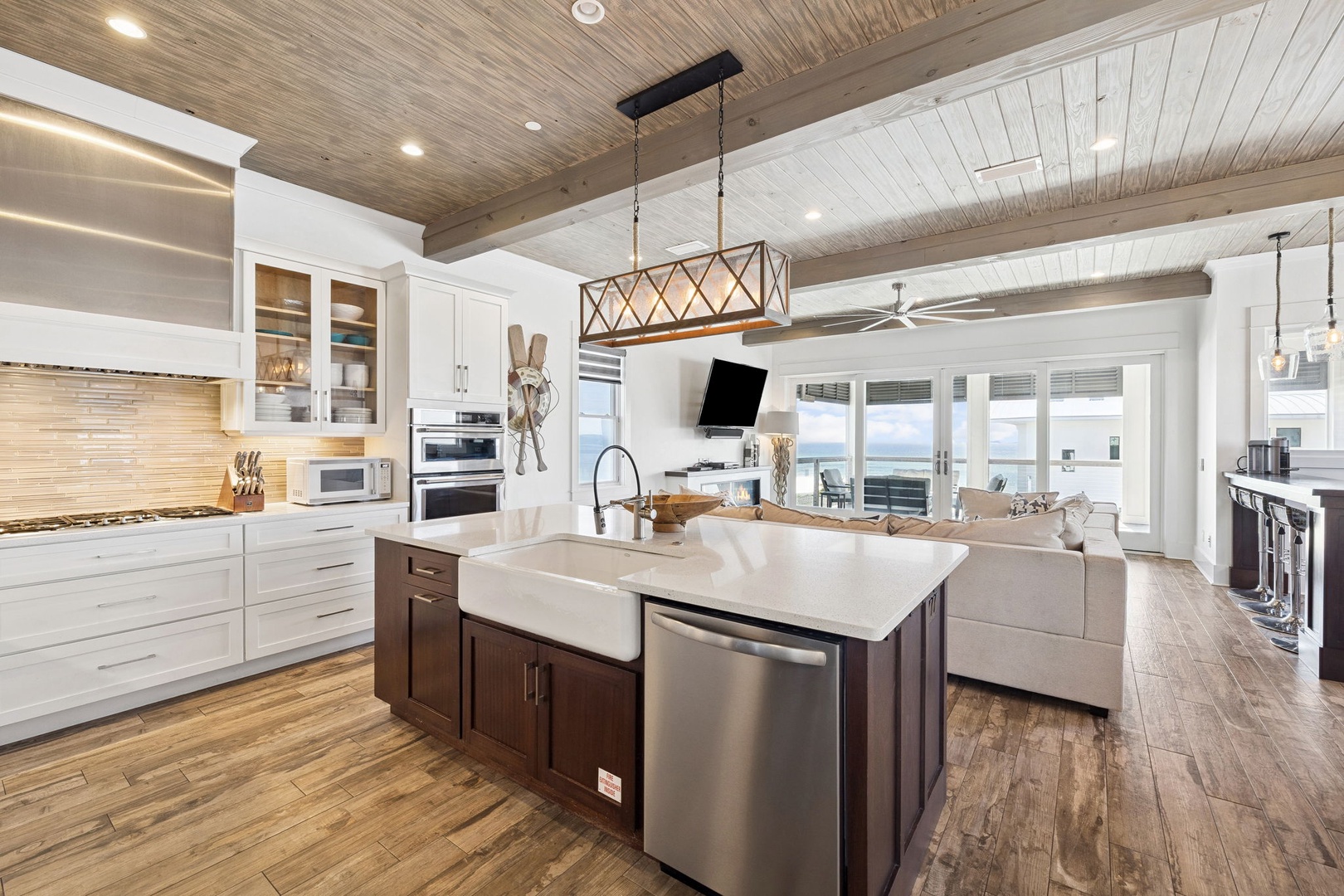 Your gourmet kitchen flows seamlessly into the living space, where exposed beams and ocean views create the perfect backdrop for memorable meals.