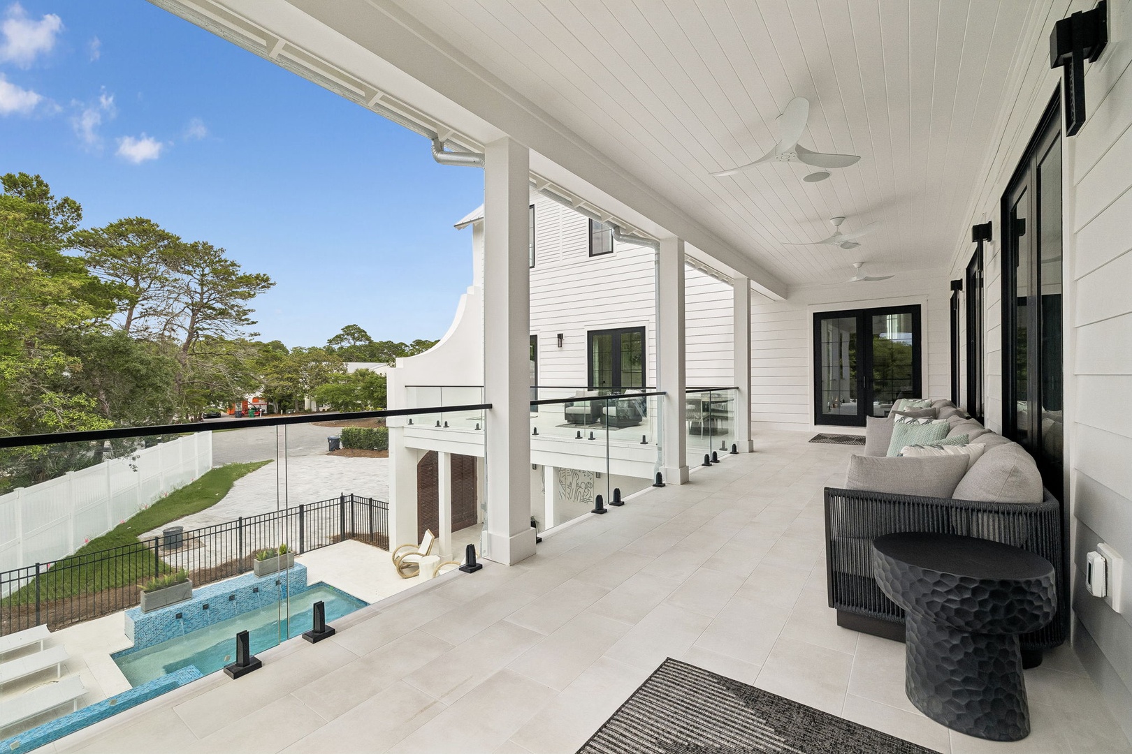 Your private covered balcony overlooks a sparkling pool, perfect for morning coffee or evening relaxation. Sink into the plush seating and let the gentle breeze refresh you.