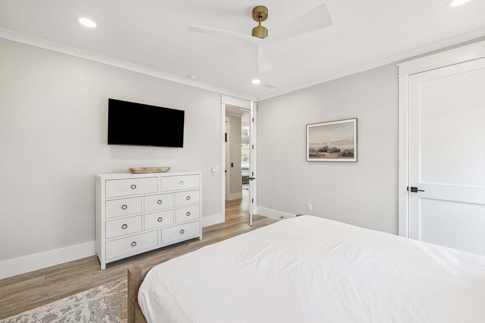 You'll love waking up in this peaceful bedroom with crisp white linens, modern TV, and elegant furnishings creating your perfect retreat.