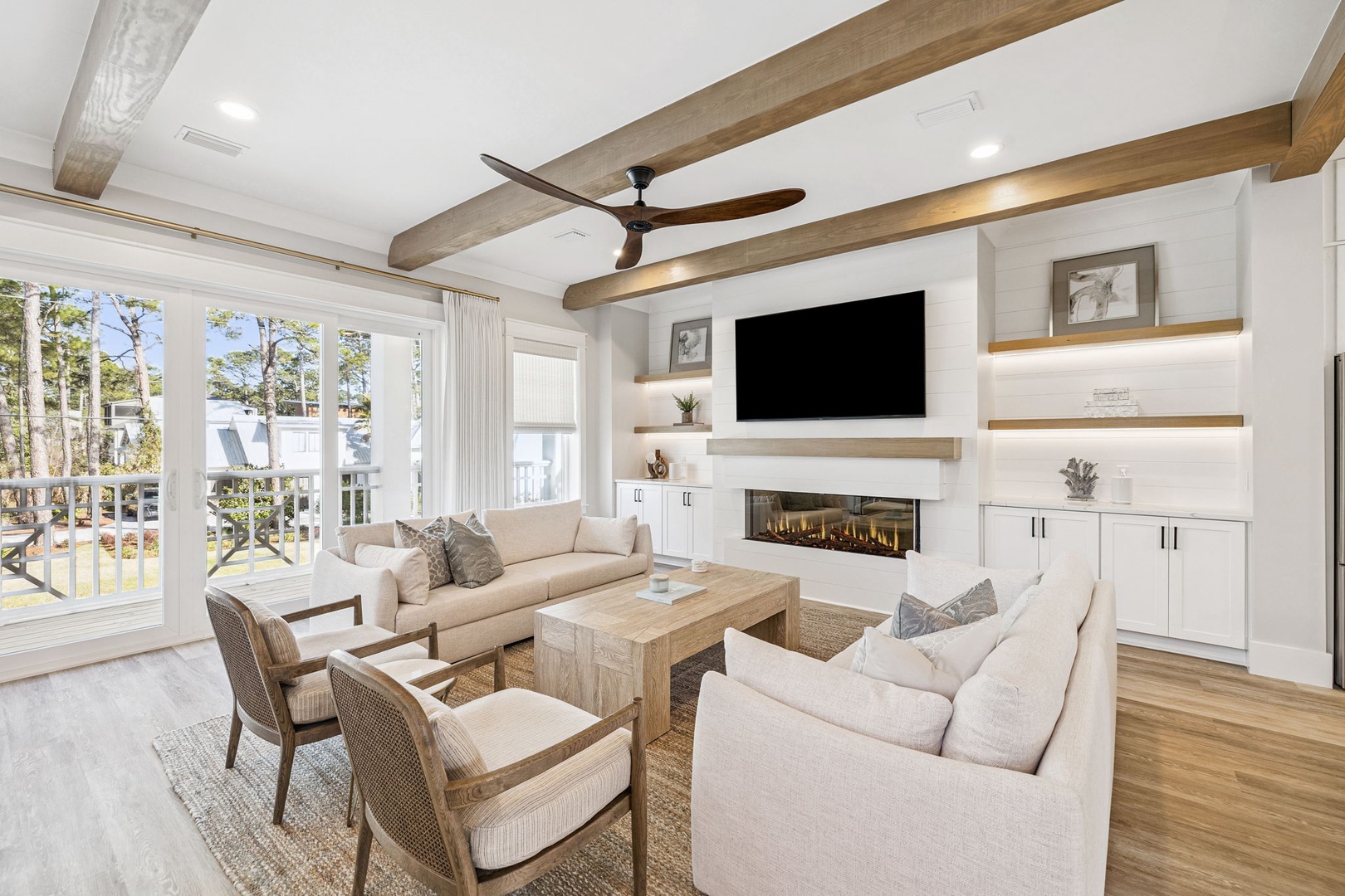 Relax in your elegant living room with exposed beams, modern fireplace, and natural light streaming through windows.