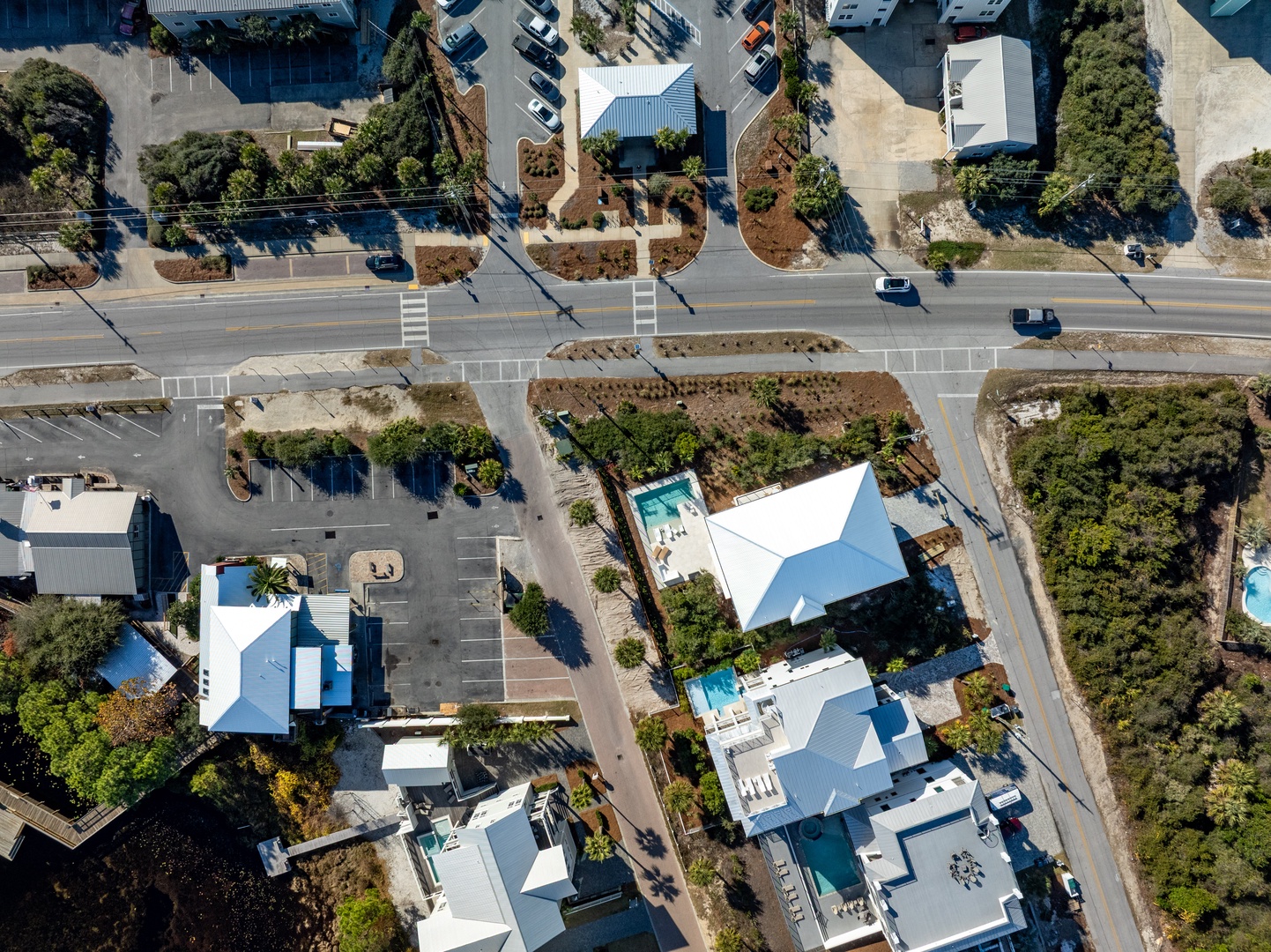 Aerial view of residential neighborhood with modern homes, swimming pools, and tree-lined streets creating a peaceful community setting.